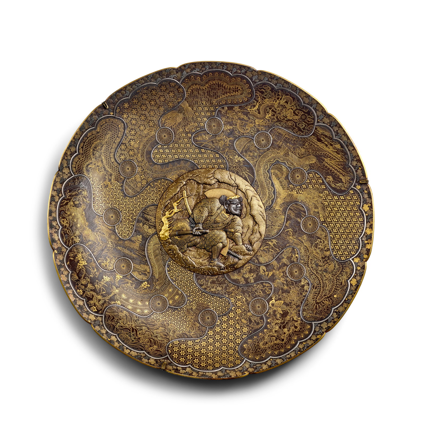 KOMAI OTOJIRŌ (1842-1917) A Large Overlaid-Iron Circular Lobed Charger Meiji era (1868-1912...: KOMAI OTOJIRŌ (1842-1917) A Large Overlaid-Iron Circular Lobed Charger Meiji era (1868-1912), 1886 or later Set on a low ring foot, with nunome zōgan (hammered overlay) of gold and silver an