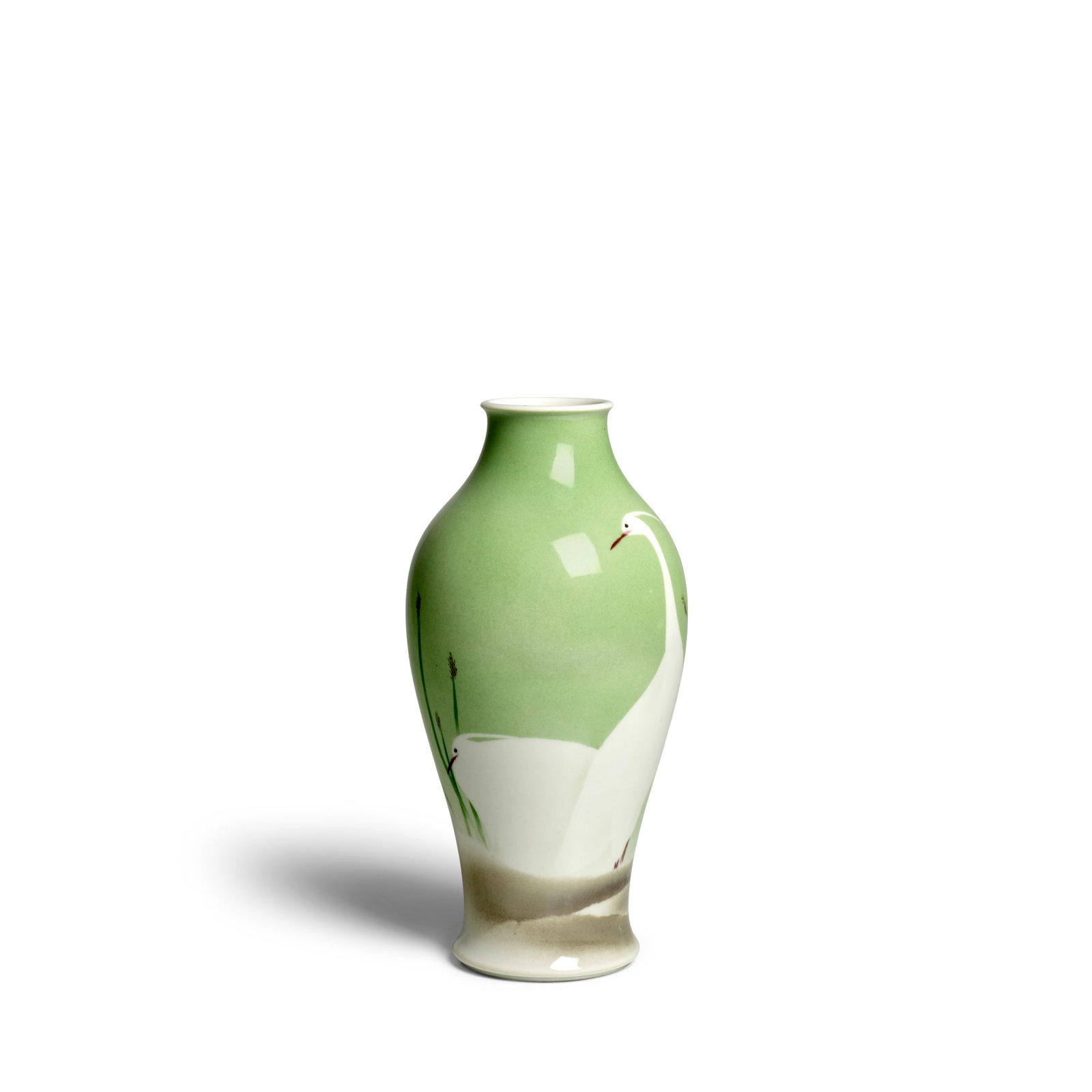 MAKUZU (MIYAGAWA) KŌZAN (1842-1916) A Porcelain Vase Showa era (1926-1989), early 20th century: MAKUZU (MIYAGAWA) KŌZAN (1842-1916) A Porcelain Vase Showa era (1926-1989), early 20th century Decorated with two white herons reserved against a modulated green ground and surrounded by spires o