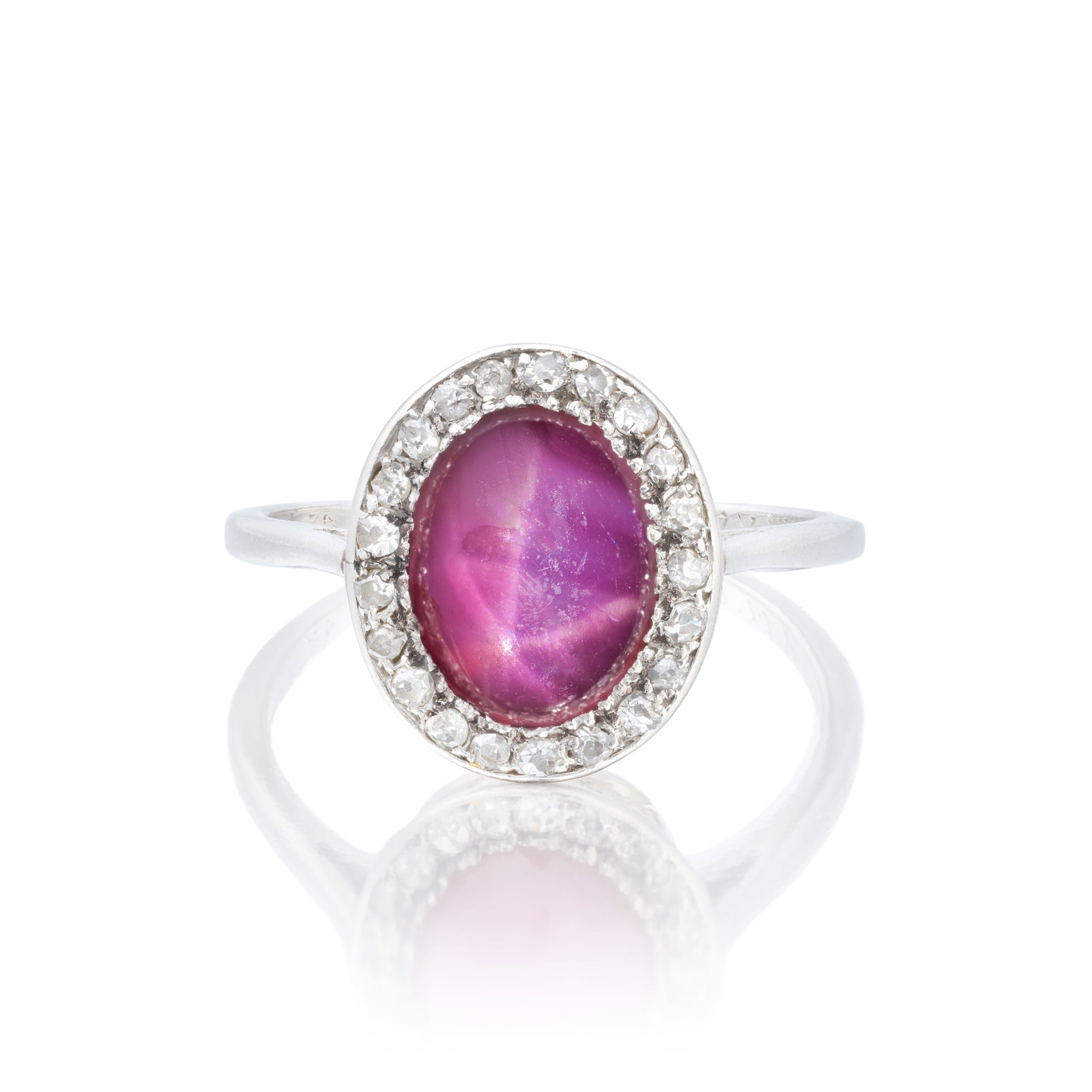 STAR RUBY AND DIAMOND CLUSTER RING: STAR RUBY AND DIAMOND CLUSTER RING The star ruby cabochon within a surround of old single-cut diamonds, ring size approx. O For further information on this lot please visit Bonhams.com