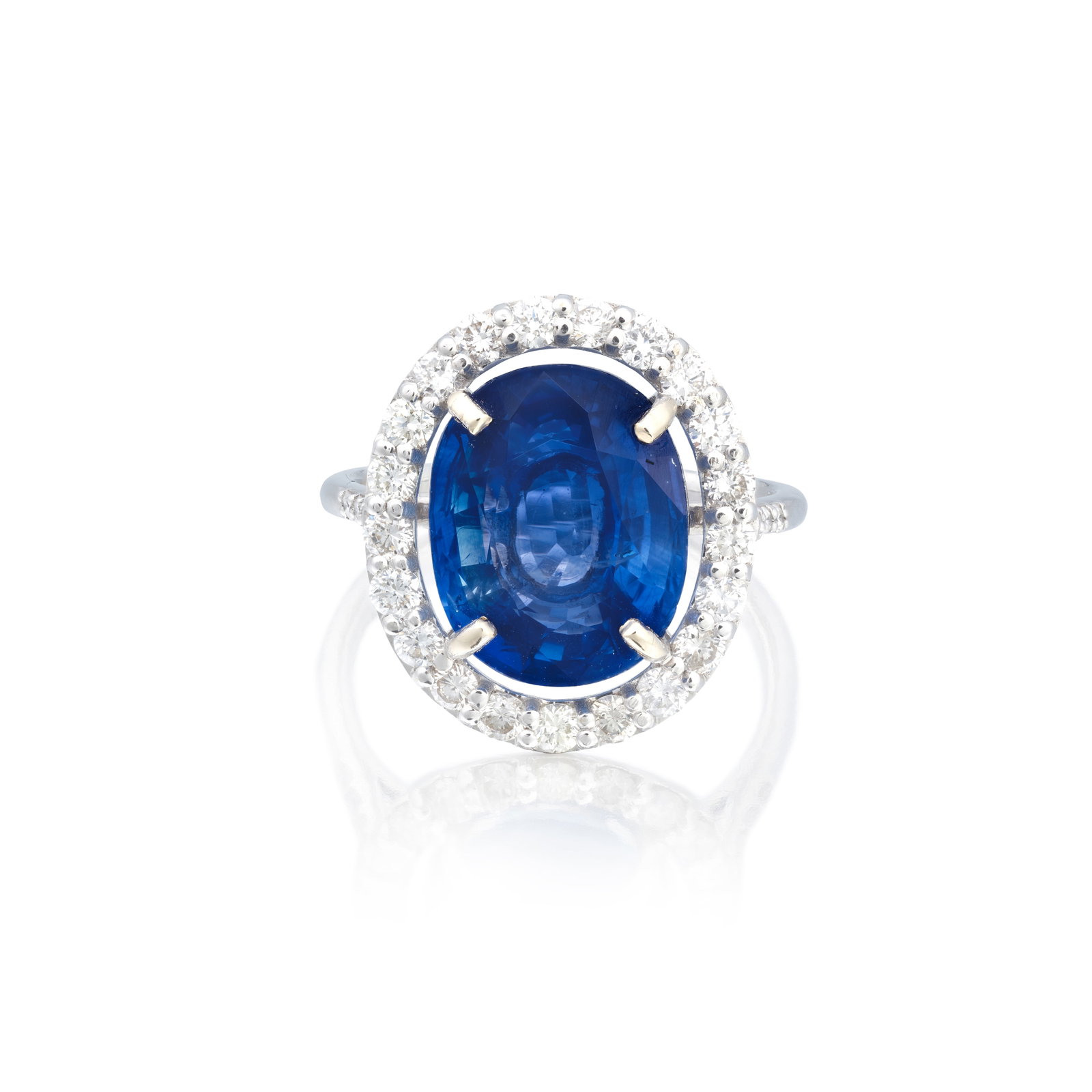 SAPPHIRE AND DIAMOND CLUSTER RING, 2025: SAPPHIRE AND DIAMOND CLUSTER RING, 2025 The oval-cut sapphire within a surround of brilliant-cut diamonds, mounted in 18 carat white gold, London hallmark, ring size approx. L For further information 