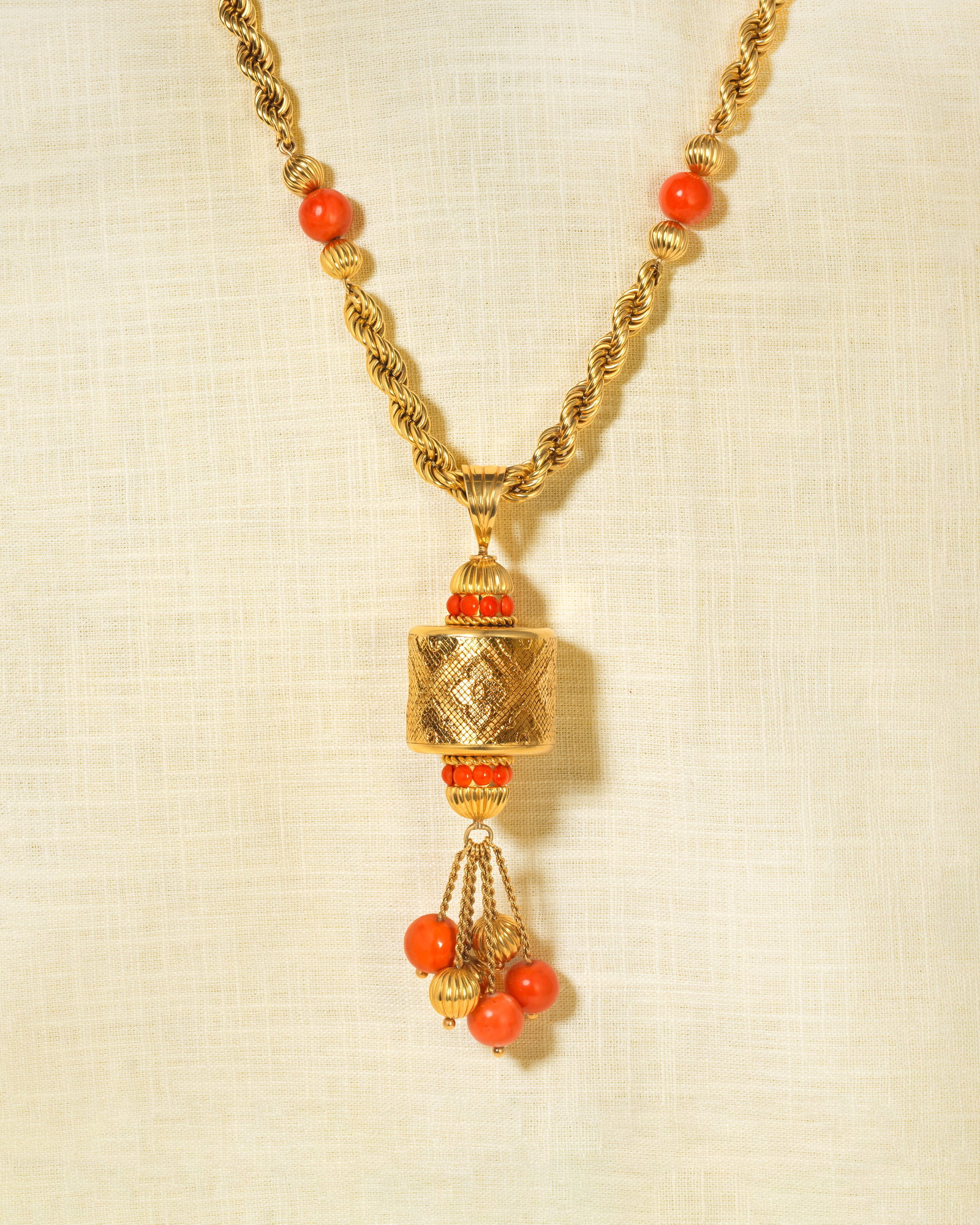 VAN CLEEF & ARPELS: CORAL SAUTOIR, CIRCA 1971: VAN CLEEF & ARPELS: CORAL SAUTOIR, CIRCA 1971 The pendant of woven cylindrical form decorated with quatrefoil patterns, between coral corallium rubrum cabochons and fluted caps, issuing coral and