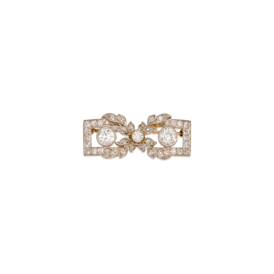AN ANTIQUE PLATINUM, GOLD AND DIAMOND BROOCH: AN ANTIQUE PLATINUM, GOLD AND DIAMOND BROOCH • Platinum topped 14K yellow gold • Numerous round shaped diamonds weighing approximately 0.95 carat total • Measures 1 1/16 in. x 1/2