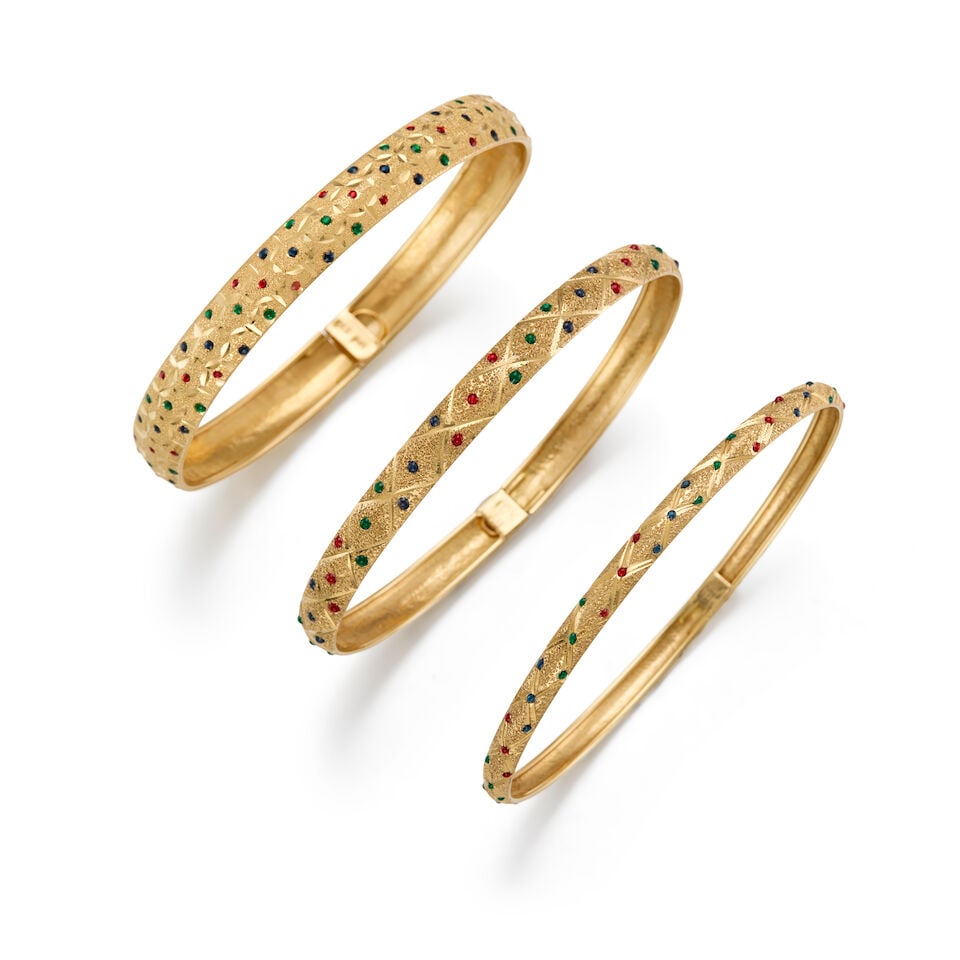 THREE GOLD AND GLASS BANGLES: THREE GOLD AND GLASS BANGLES • A 10K yellow gold bangle with numerous round shaped glass, inner circumference 7 in. • A 10K yellow gold bangle with numerous round shaped glass, inner