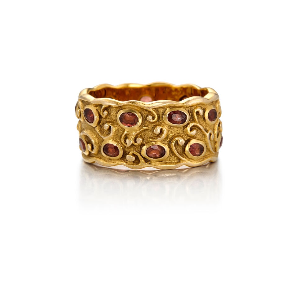 14K YELLOW GOLD AND GARNET RING: 14K YELLOW GOLD AND GARNET RING • Eighteen oval shaped garnets measuring approximately 2.85mm x 2.01mm • Size 6 3/4 • Estimated gross weight: 8.7 grams Footnotes: Tuulikki Suominen