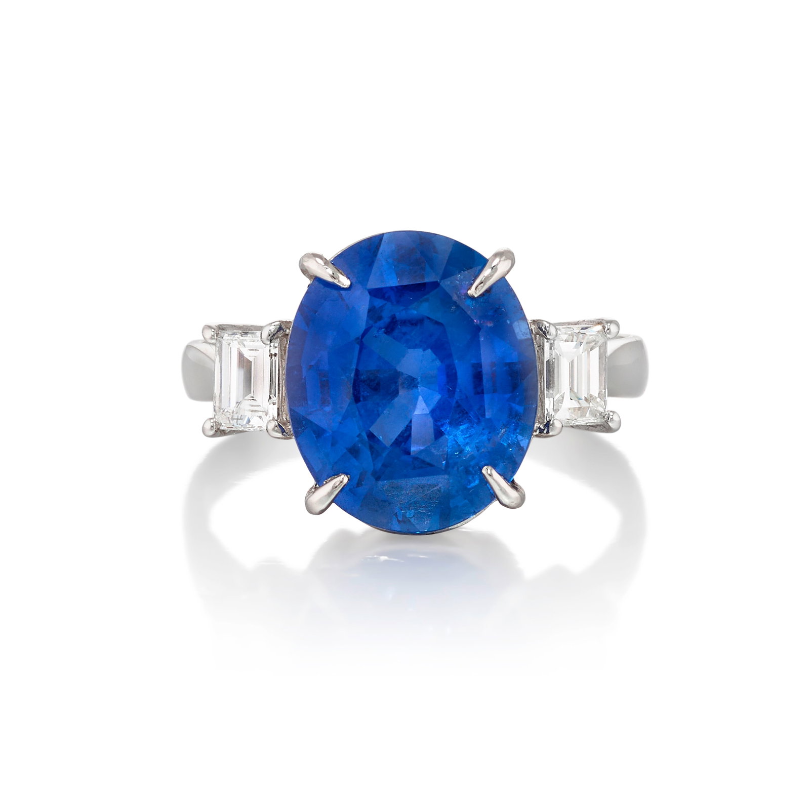 A PLATINUM, SAPPHIRE AND DIAMOND RING: A PLATINUM, SAPPHIRE AND DIAMOND RING Centering an oval-shaped sapphire, flanked by octagonal step-cut diamonds; estimated total sapphire weight 6.45 carats; estimated total diamond weight 0.50