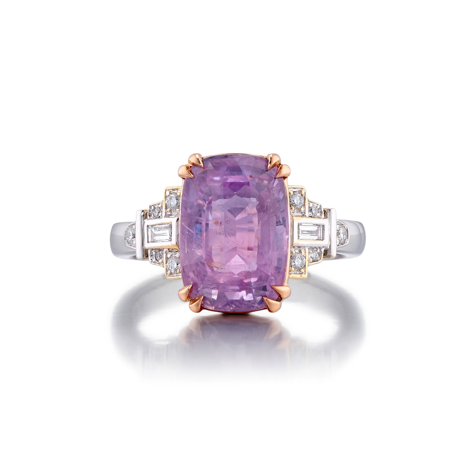 AN 18K BICOLOR GOLD, PINKISH-PURPLE SAPPHIRE AND DIAMOND RING: AN 18K BICOLOR GOLD, PINKISH-PURPLE SAPPHIRE AND DIAMOND RING Centering a cushion-shaped, mixed-cut, pinkish-purple sapphire, weighing 6.01 carats, flanked by round brilliant and baguette-cut diamonds