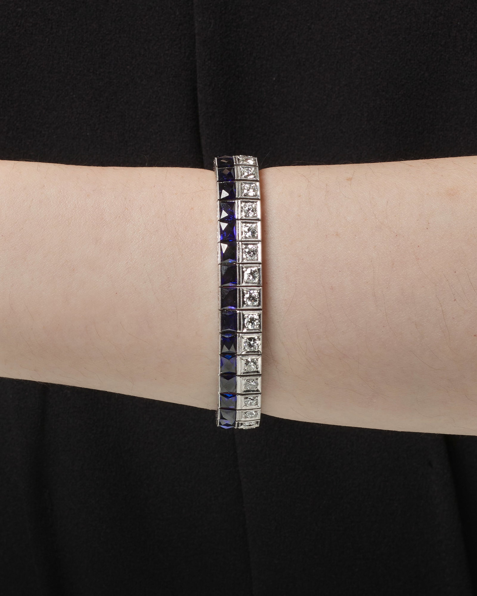 CARTIER: A DIAMOND AND SYNTHETIC SAPPHIRE BRACELET, CIRCA 1925: CARTIER: A DIAMOND AND SYNTHETIC SAPPHIRE BRACELET, CIRCA 1925 A strap bracelet, comprising a row of old European and transitional-cut diamonds and a row of French-cut synthetic sapphires; signed L. C