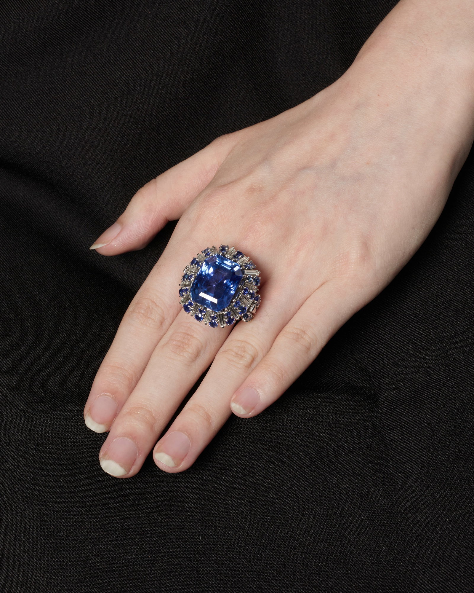 A PLATINUM, SAPPHIRE AND DIAMOND CONVERTIBLE RING: A PLATINUM, SAPPHIRE AND DIAMOND CONVERTIBLE RING Centering a rectangular, emerald-cut sapphire weighing 24.69 carats, in a mounting accented with round sapphires and tapered-baguette and