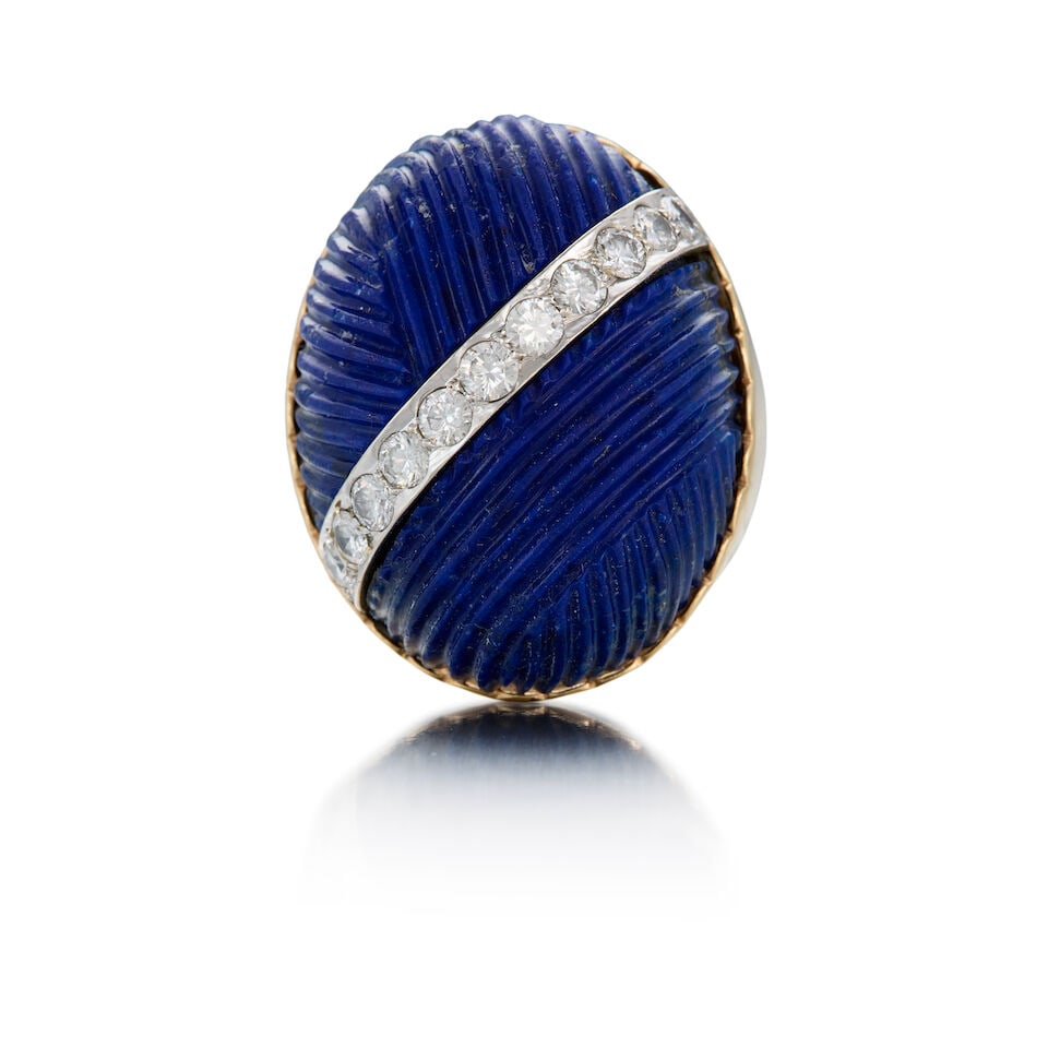 14K YELLOW GOLD, LAPIS LAZULI, AND DIAMOND RING: 14K YELLOW GOLD, LAPIS LAZULI, AND DIAMOND RING • One oval carved cabochon lapis lazuli measuring approximately 31.64mm x 24.57mm x 15.75mm • Eleven round brilliant cut diamonds weighing