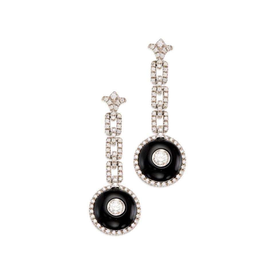 18K WHITE GOLD, ONYX AND DIAMOND EARRINGS: 18K WHITE GOLD, ONYX AND DIAMOND EARRINGS • Two carved and drilled onyx pieces measuring approximately 15.10mm in diameter • Two round brilliant cut diamonds weighing approximately 0.65