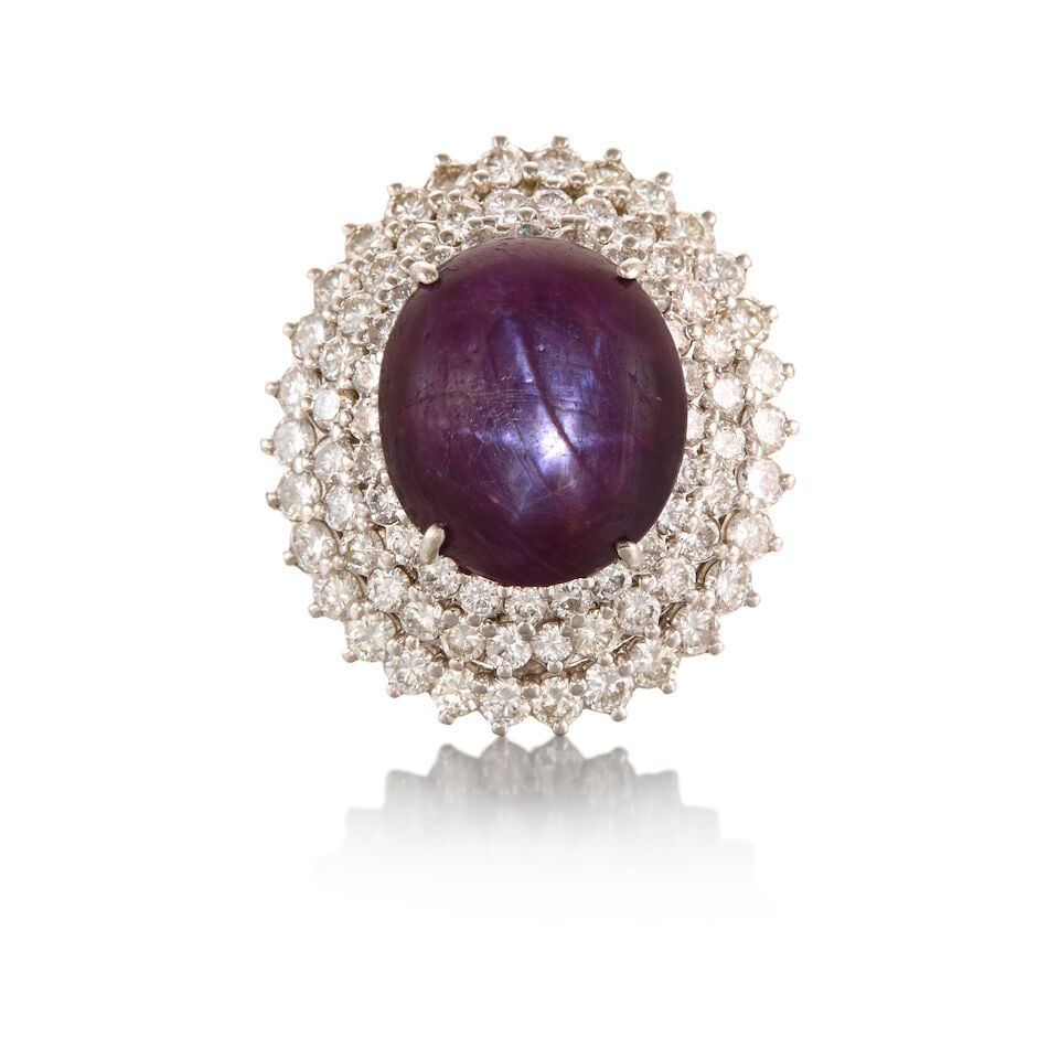 PLATINUM, STAR RUBY, AND DIAMOND RING: PLATINUM, STAR RUBY, AND DIAMOND RING • One oval cabochon star sapphire measuring approximately 16.79mm x 14.56mm x depth cannot be determined due to the setting • Numerous round shaped di