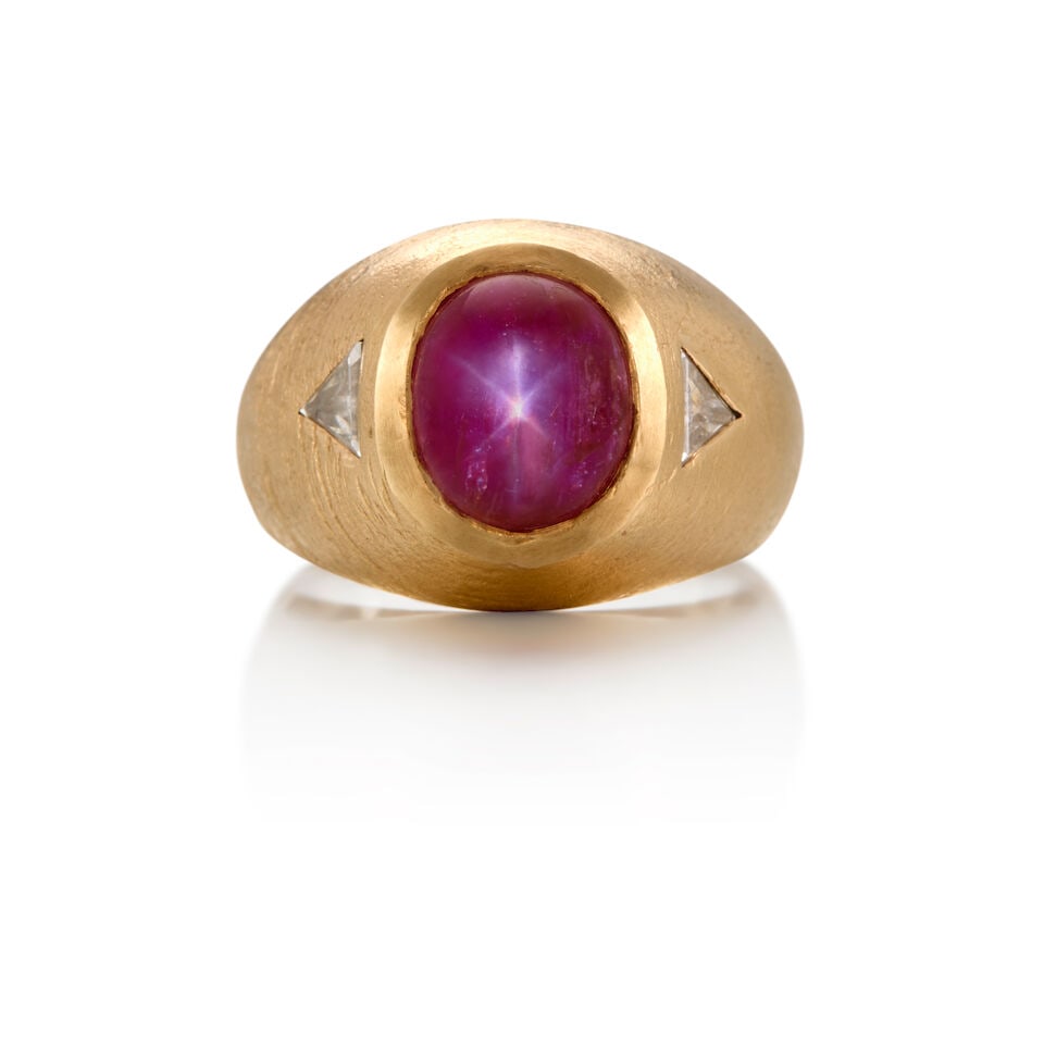 13K GOLD, STAR RUBY AND DIAMOND RING: 13K GOLD, STAR RUBY AND DIAMOND RING • One oval cabochon-shaped star ruby weighing approximately 5.06 carats • Two triangle-shaped diamonds weighing approximately 0.44 carat total •