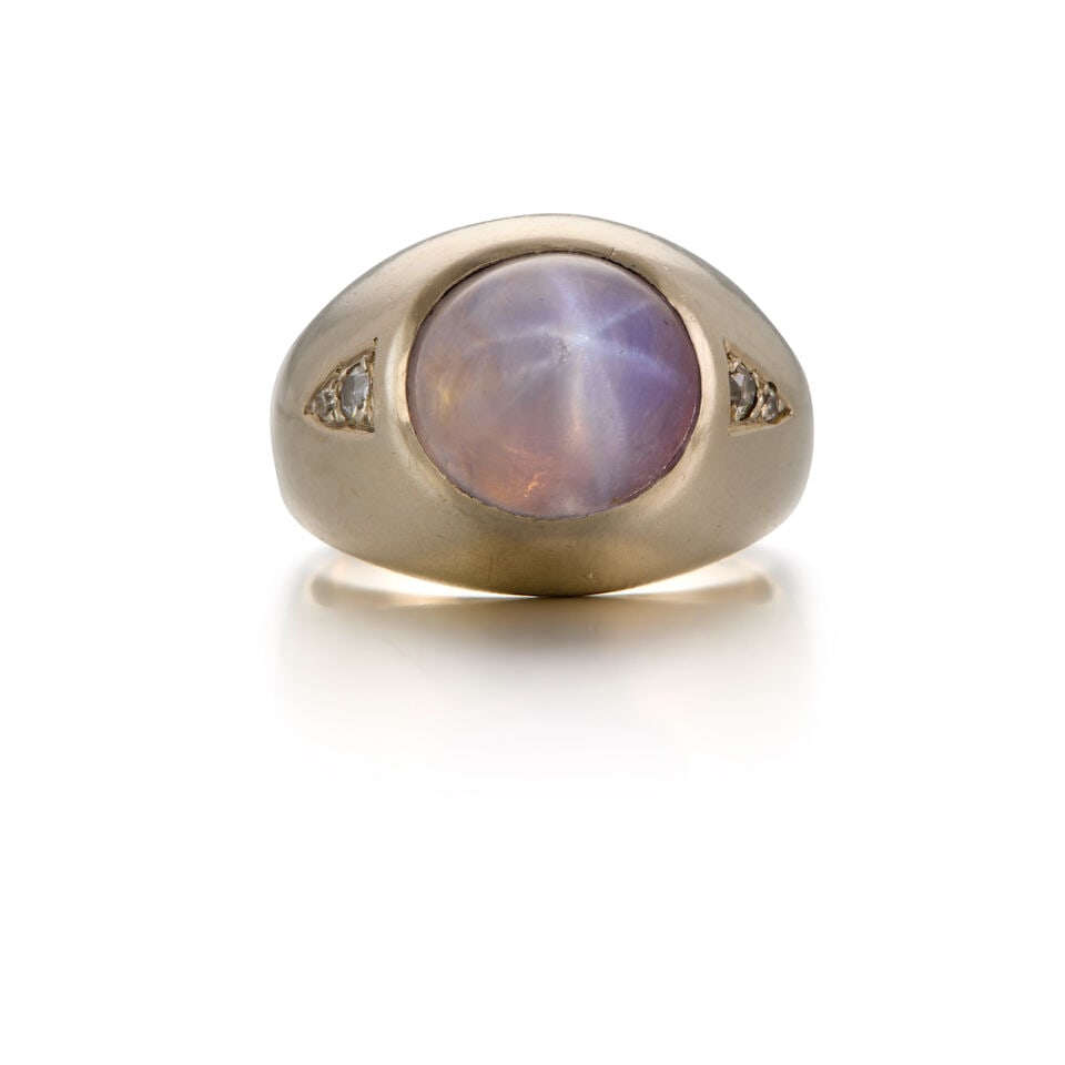 14K WHITE GOLD, STAR SAPPHIRE AND DIAMOND RING: 14K WHITE GOLD, STAR SAPPHIRE AND DIAMOND RING • One dome cabochon star sapphire weighing approximately 6.88 carats • Two single cut diamonds weighing approximately 0.11 carat total