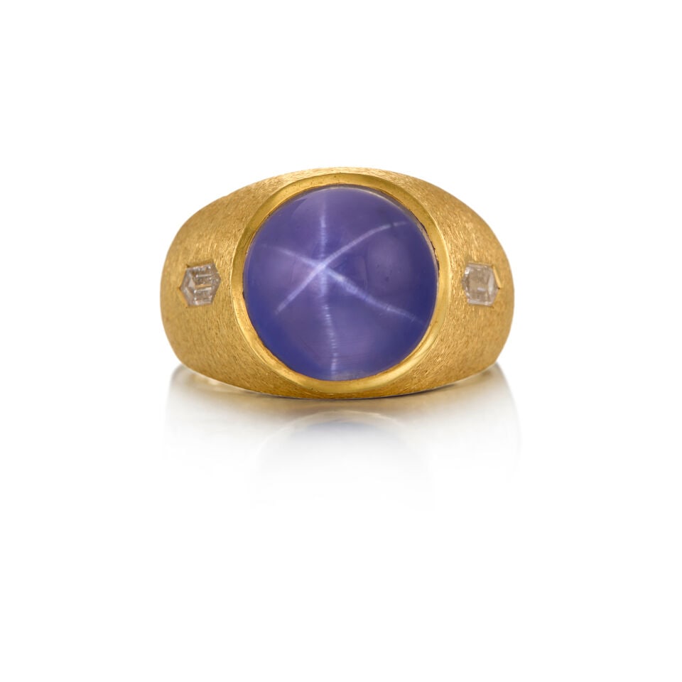 18K STAR SAPPHIRE AND DIAMOND RING: 18K STAR SAPPHIRE AND DIAMOND RING • One round cabochon-shaped star sapphire weighing approximately 14.80 carats • Two long hexagonal-shaped diamonds weighing approximately 0.34 carat