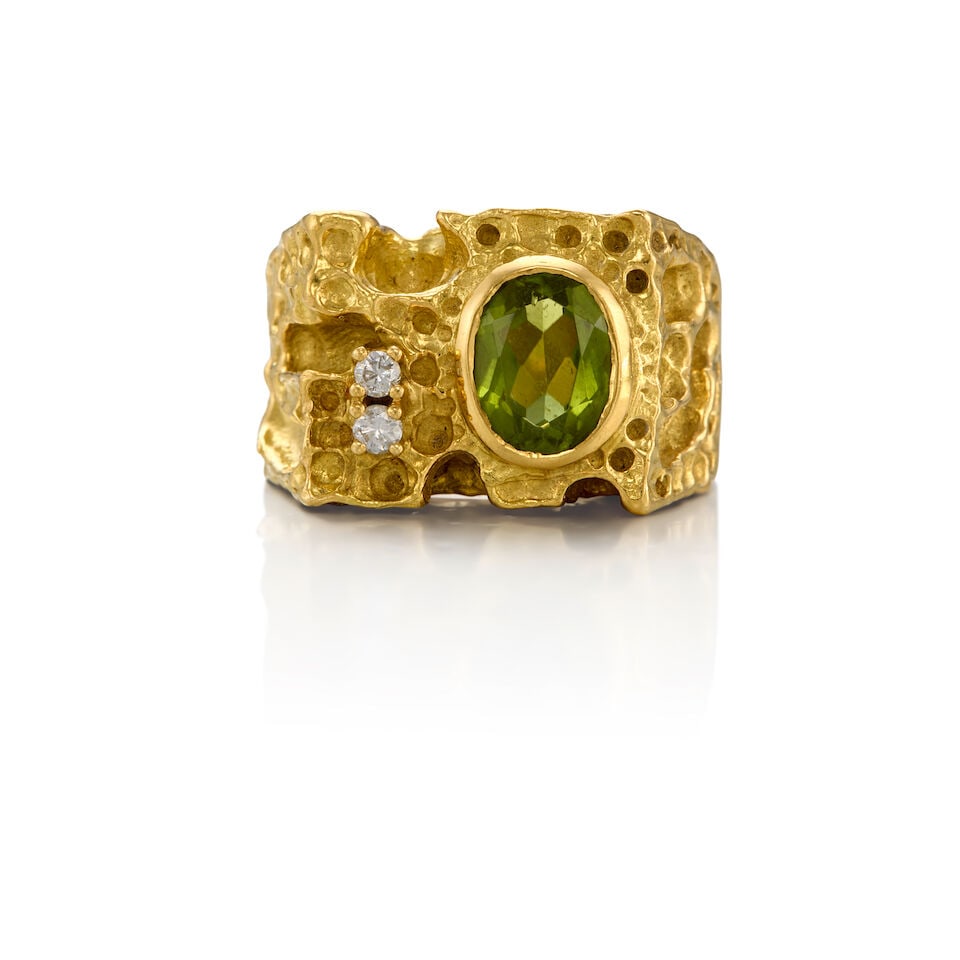 AN 18K GOLD, PERIDOT AND DIAMOND RING: AN 18K GOLD, PERIDOT AND DIAMOND RING • One oval-shaped peridot weighing approximately 1.28 carats • Two round-shaped diamonds weighing approximately 0.08 carat total • Size 5