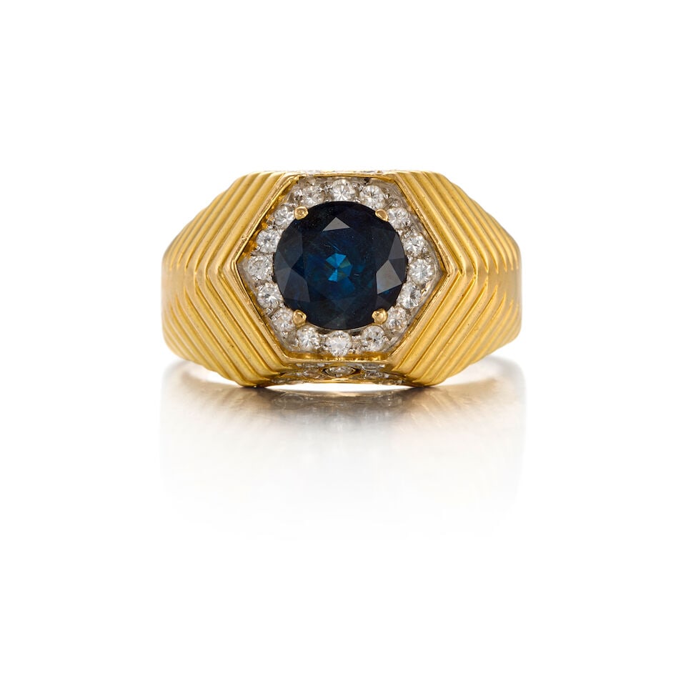 18K GOLD, SAPPHIRE AND DIAMOND RING: 18K GOLD, SAPPHIRE AND DIAMOND RING • One round-shaped sapphire weighing approximately 1.58 carats • Thirty round brilliant-cut diamonds weighing approximately 0.46 carat • Size 8