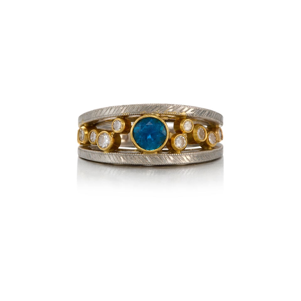 A TOPAZ AND DIAMOND RING: A TOPAZ AND DIAMOND RING • Platinum and 12K yellow gold • One round-shaped topaz weighing approximately 0.51 carat • Ten round-shaped diamonds weighing approximately 0.34 carat