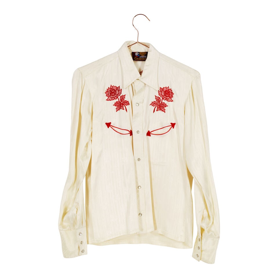 A GROUP OF VINTAGE WESTERN-THEMED CLOTHING 1980s: A GROUP OF VINTAGE WESTERN-THEMED CLOTHING 1980s Comprising a Kenny Rogers red embroidered white snap-front long sleeve blouse, small, a black satin and white fringe trimmed button-up long sleeve