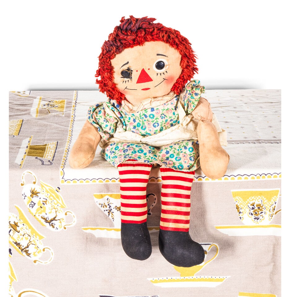 THE RAGGEDY ANN DOLL AND TEACUP PRINT TABLECLOTH FROM THE 'GIRLS JUST WANT TO HAVE FUN' MUSIC VI...: THE RAGGEDY ANN DOLL AND TEACUP PRINT TABLECLOTH FROM THE 'GIRLS JUST WANT TO HAVE FUN' MUSIC VIDEO 1983 height of doll 16in Footnotes: When Cyndi Lauper's breakout hit 'Girls Just Want to Have Fun'