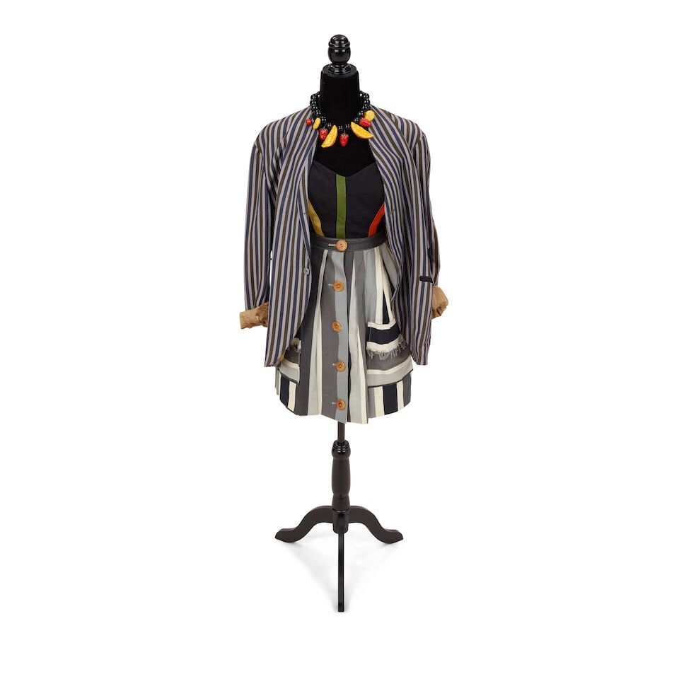 TWO STAGE AND PRESENTATION-WORN LOOKS 1984-1986: TWO STAGE AND PRESENTATION-WORN LOOKS 1984-1986 First look: a fruit necklace, a blue, grey, and green striped Stuart Clothes blazer, a Cole of California black and multi-colored striped vintage bathin