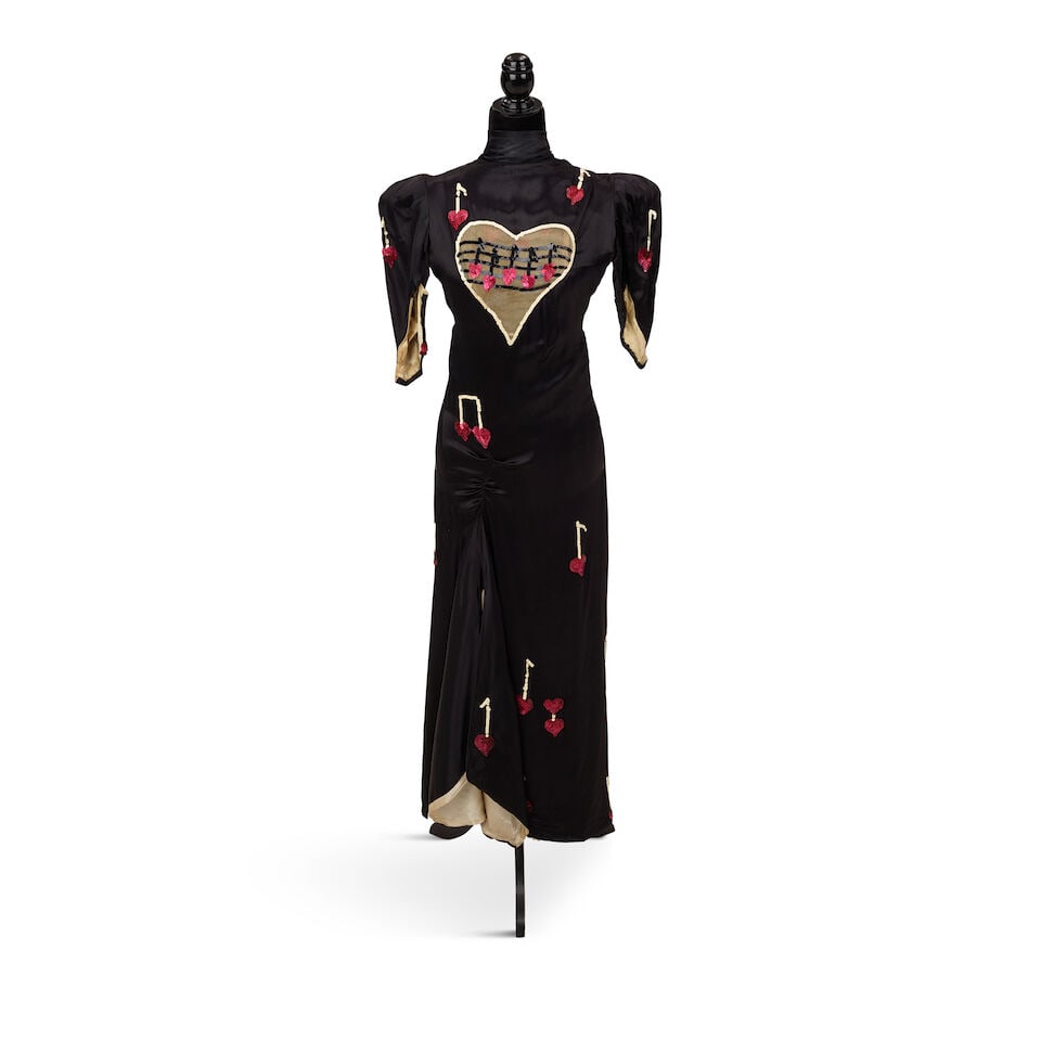 A VINTAGE SEQUIN EMBELLISHED BLACK SATIN 'MUSIC NOTE' DRESS 1994: A VINTAGE SEQUIN EMBELLISHED BLACK SATIN 'MUSIC NOTE' DRESS 1994 Footnotes: Worn onstage during the Twelve Deadly Cyns World Tour at the Paris Sports Palace in Paris, France, 19 November 1994. This