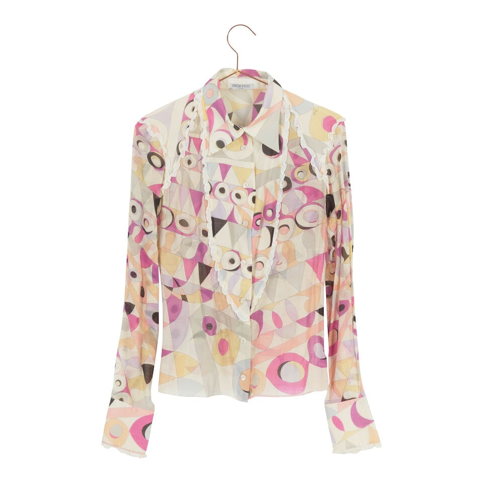 A GROUP OF VINTAGE EMILIO PUCCI CLOTHING 1990s: A GROUP OF VINTAGE EMILIO PUCCI CLOTHING 1990s Comprising a sheer ruffle button-up blouse, 42, a button-up blouse, 42, a sheer skirt, and a pair of pants, 44. (4) This lot is subject to the following