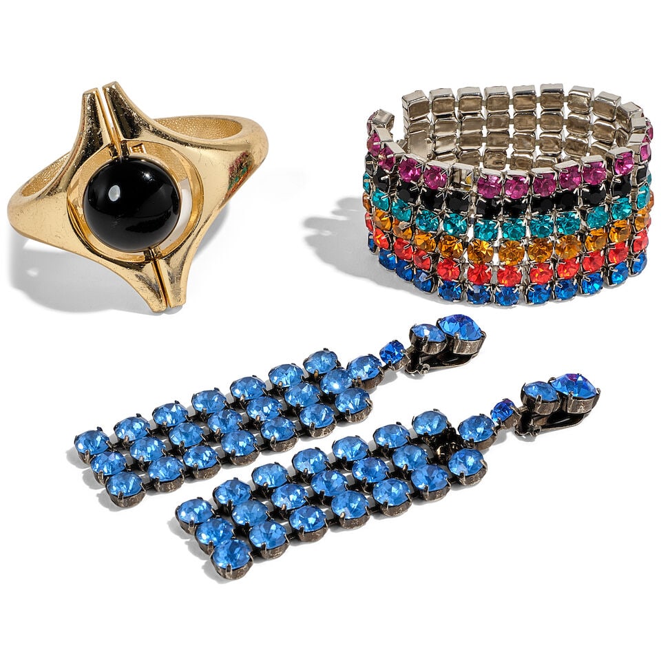 THREE ICONIC JEWELRY PIECES 1980s: THREE ICONIC JEWELRY PIECES 1980s Comprising a pair of blue rhinestone earrings, a multicolor rhinestone bracelet, and a gold-tone cuff. (3) Footnotes: The pieces worn throughout the 1980s, including 