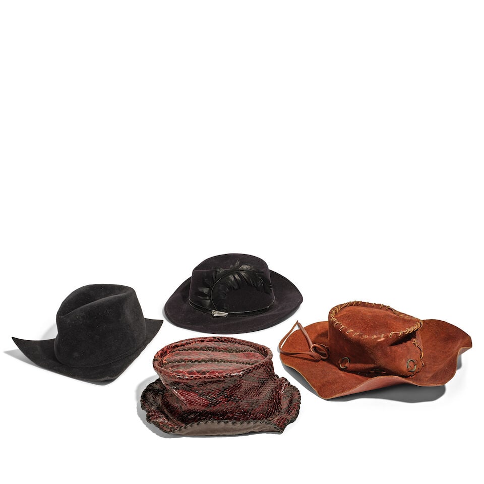 A BLACK FELT ANGULAR COWBOY HAT FROM THE 'FUNNEL OF LOVE' MUSIC VIDEO2016: A BLACK FELT ANGULAR COWBOY HAT FROM THE 'FUNNEL OF LOVE' MUSIC VIDEO 2016 Together with a blue felt fedora with a faux black belt and feather, a red crocodile leather top hat, and a brown suede
