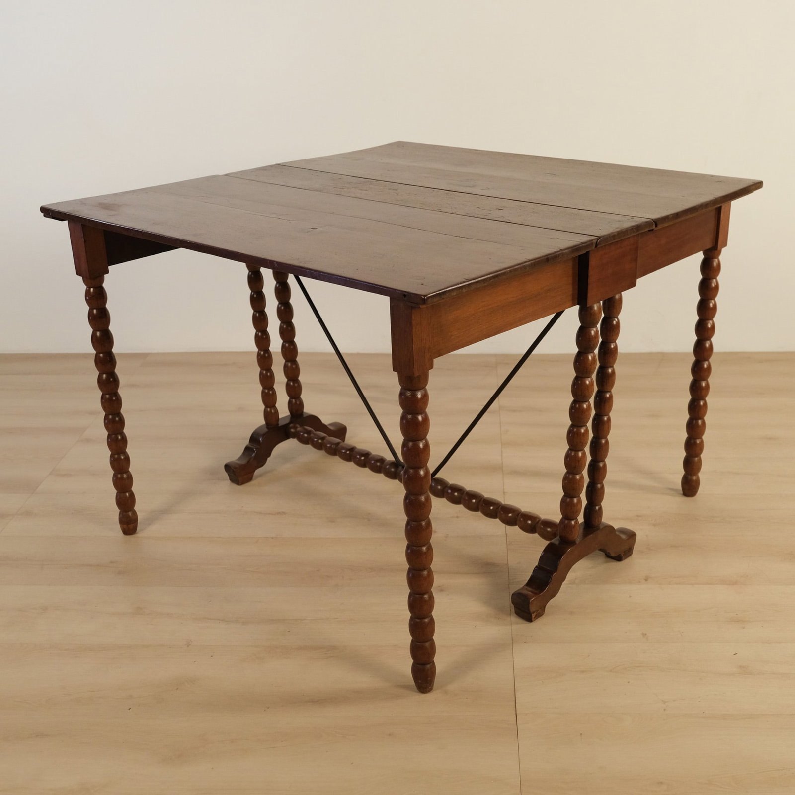 Italian Extendable Table: This Italian Extendable Table has a charmingly rustic presence, with a rectangular plank top flanked by drop leaves that create a generous square surface when raised. The base features beautifully