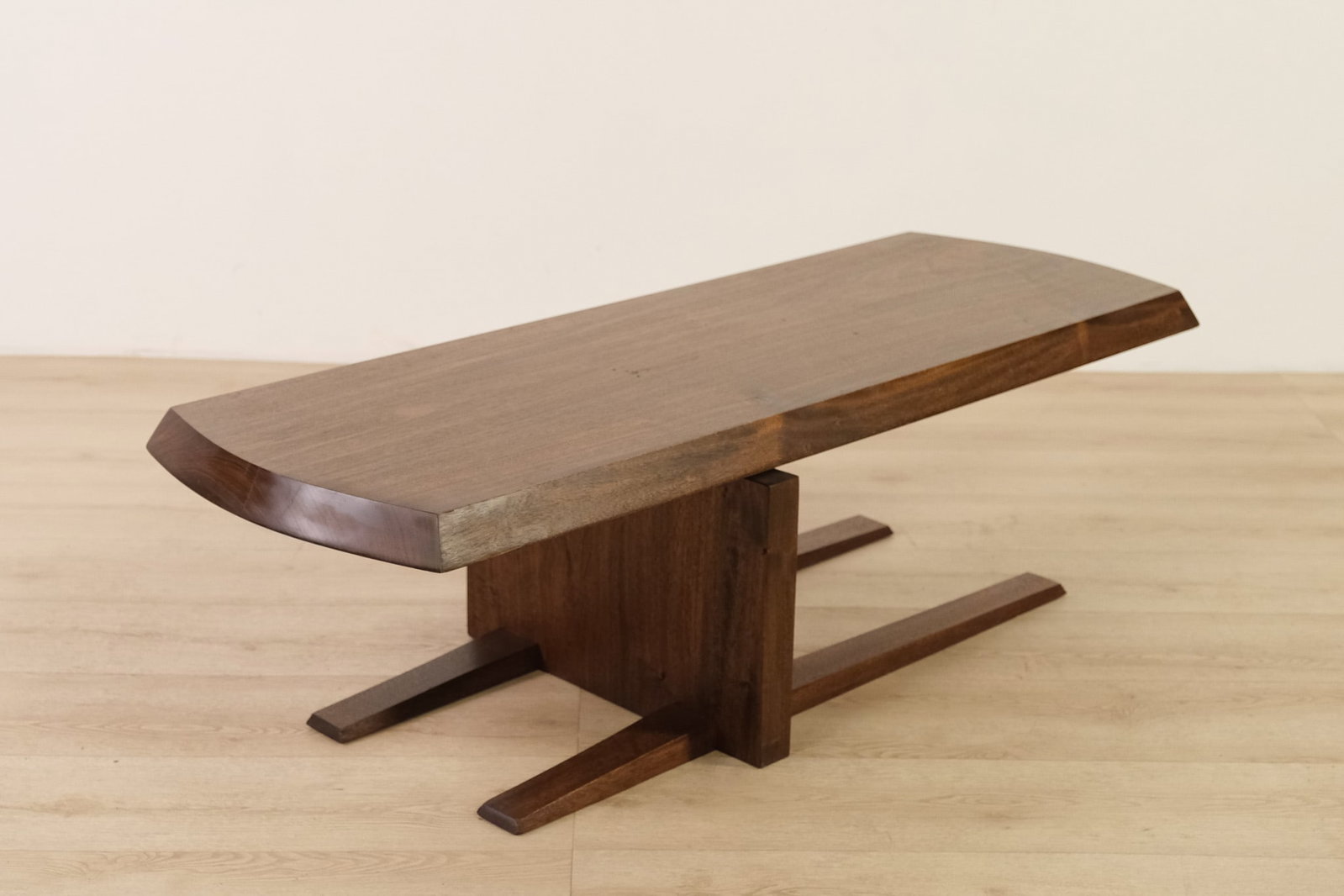 Nakashima Style, Mid-Century-Modern Coffee Table: This table features a minimalist, mid-century modern design with a thick, rectangular top showing gently angled corners and beveled edges. The base consists of a central panel support with two