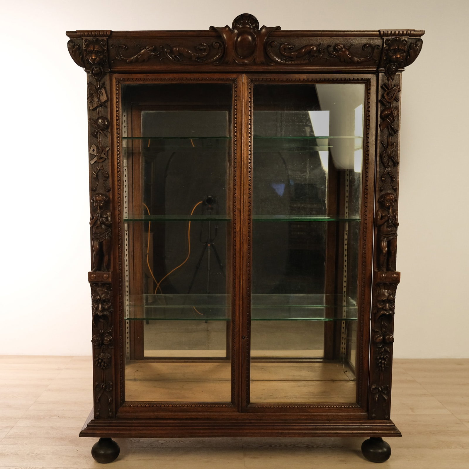 French Carved Walnut Display Cabinet: This French, carved walnut display cabinet boasts twin glazed doors and mirrored sides that flood the interior with light ideal for showcasing books, porcelain, or curios. The rich walnut is