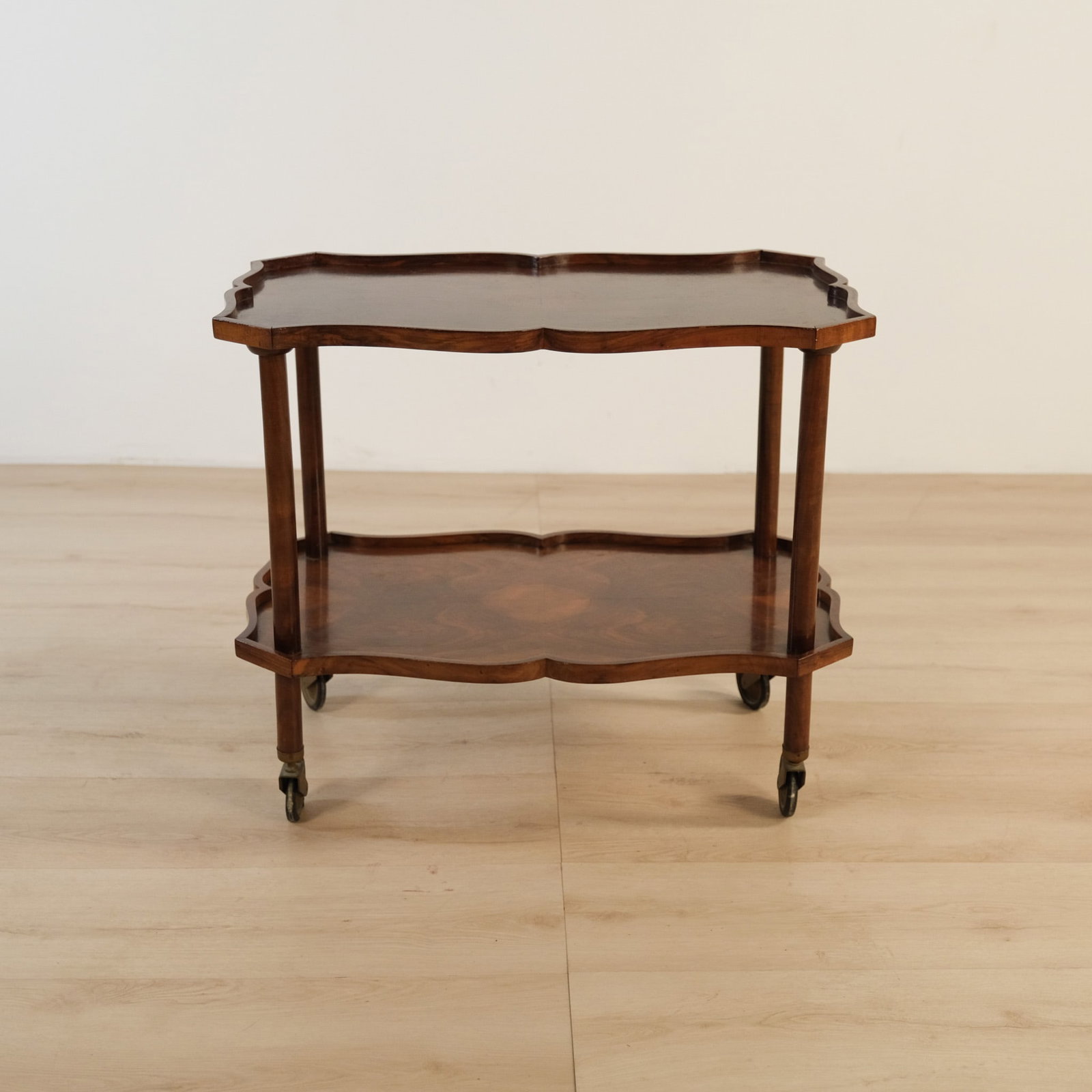 Italian Two Tier Mahogany Bar Cart/Service Trolley: This antique two-tier bar cart features a rich mahogany finish, serpentine tray tops, and petite caster wheels, offering an elegant, mobile serving surface.?Rectangular form softened by a scalloped ga