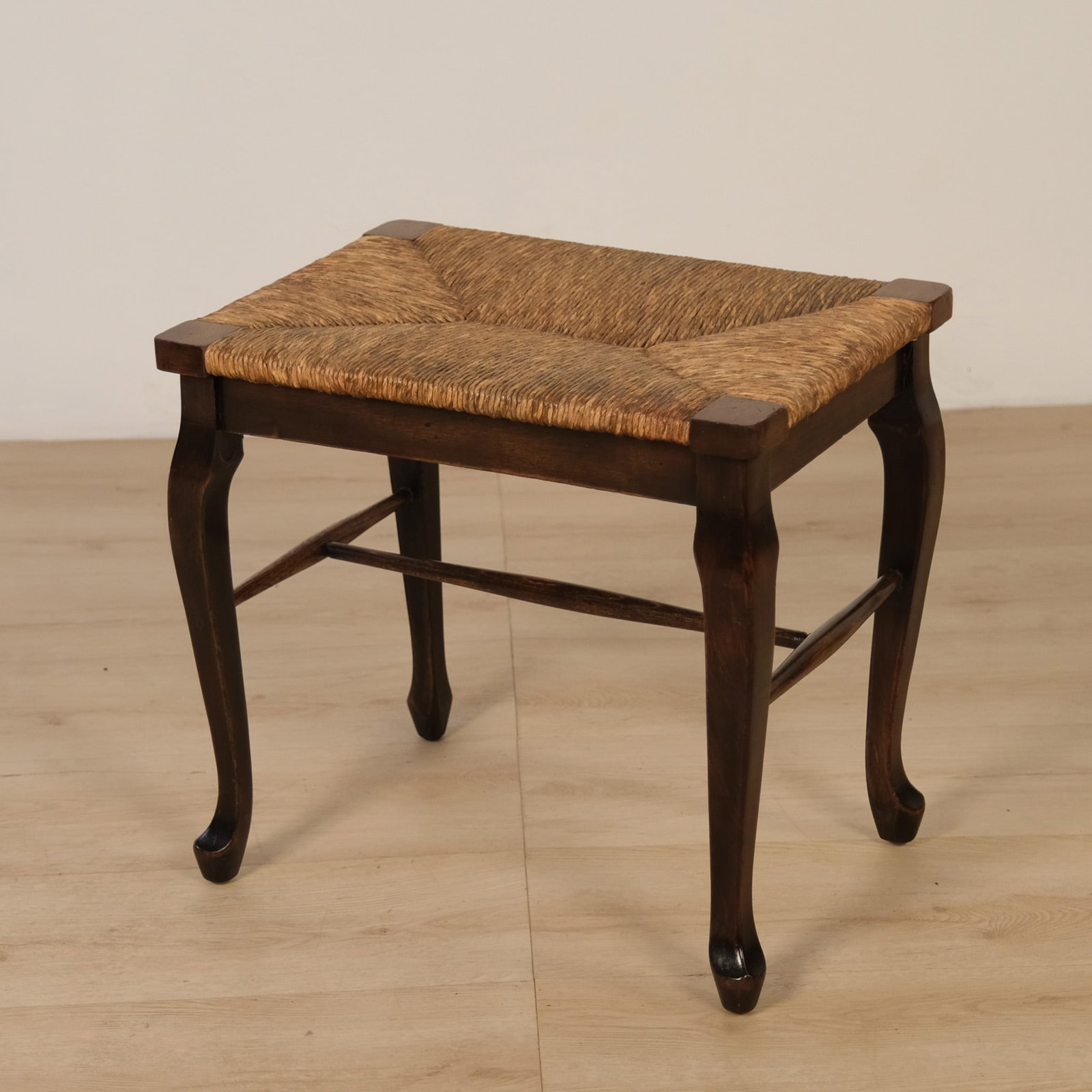 Cabriole Leg Rush Seat Stool: Wooden stool featuring a woven rush seat with a natural herringbone weave, set within a dark-stained wood frame. Raised on four gracefully curved cabriole legs, joined by a wavy stretcher for added