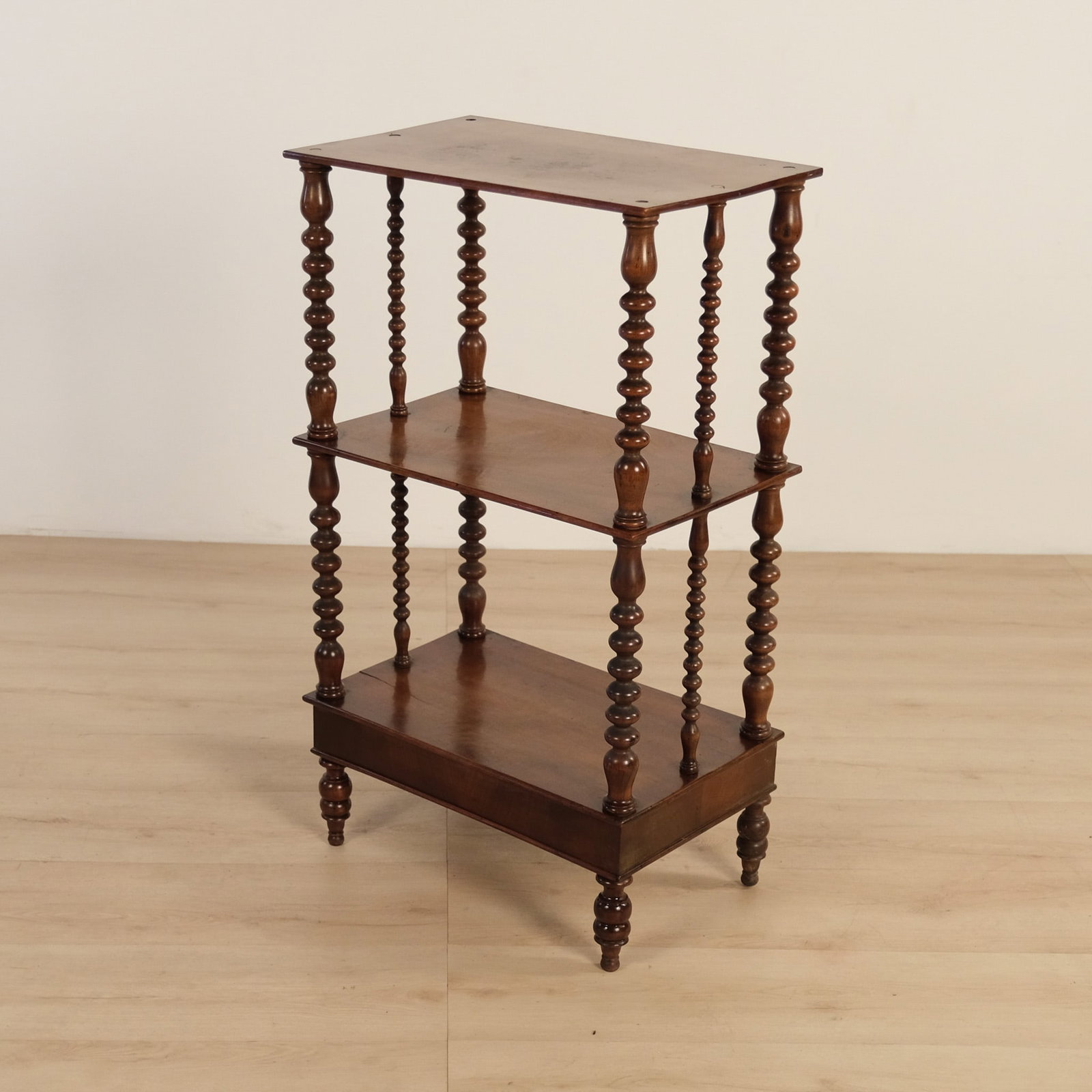 Three Tier Display Etagere: A vintage three-tier open display shelf, distinguished by it's finely turned, bobbin-style supports. Substantial at the corners with slimmer turned spindles between, giving it a strong English,