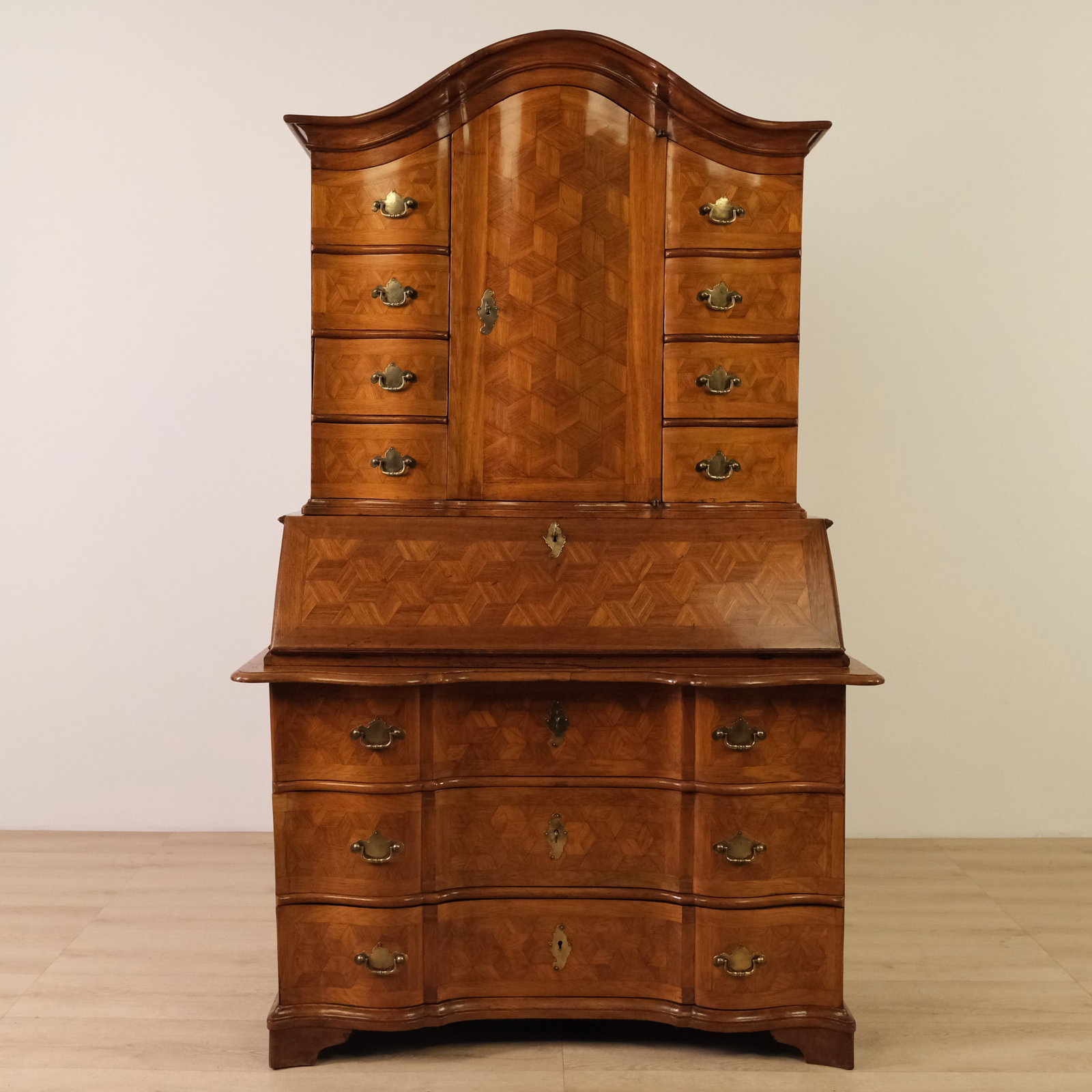 Austrian Wood Secretary, c. 1800: Austrian walnut secretary desk with a graceful serpentine form, shaped cornice and a richly figured parquetry veneer throughout. Decorative brass hardware and abundant storage make it an elegant and