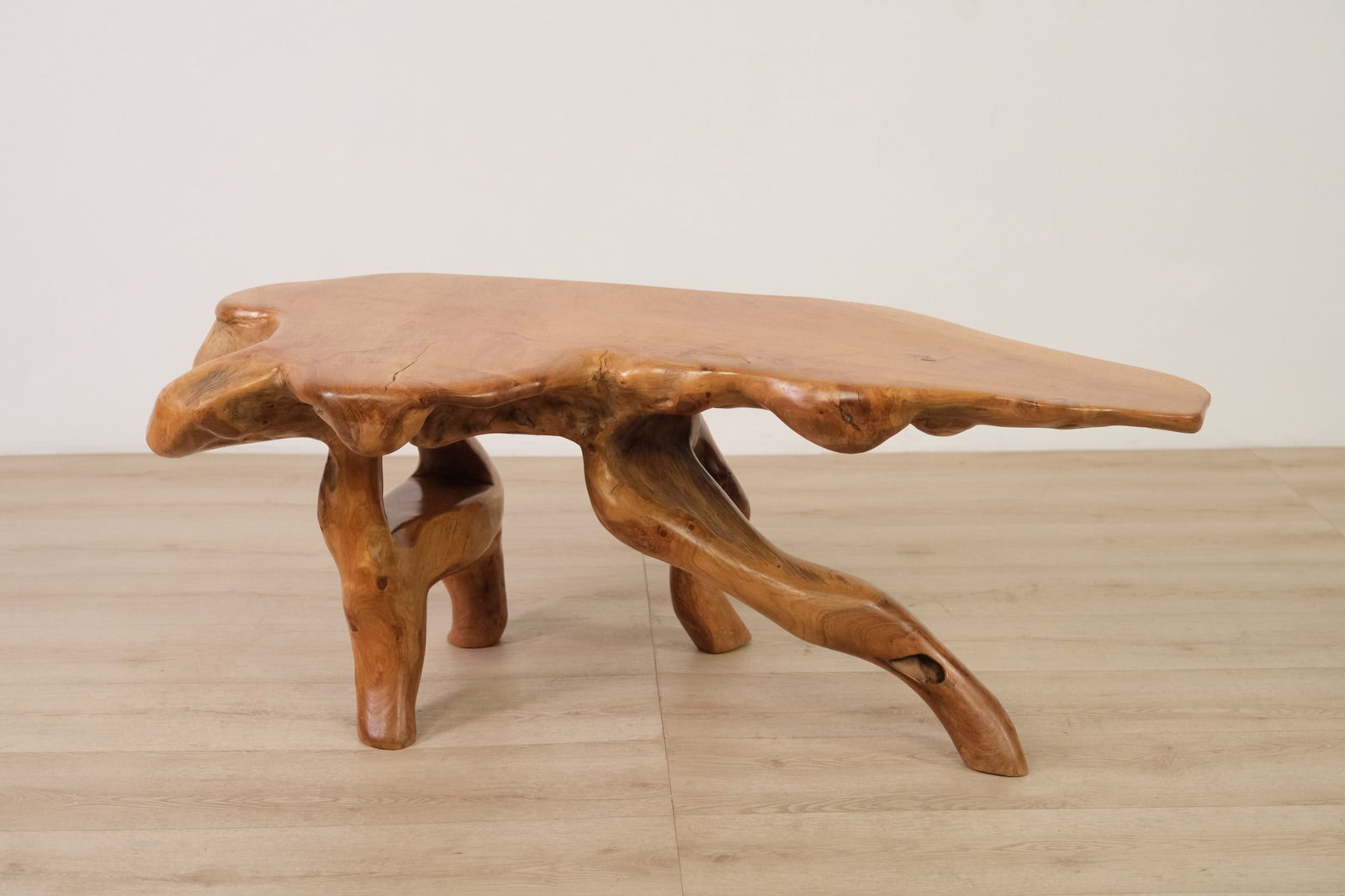 Natural Form Teak Coffee Table, c. 1960: A striking natural-form teak table crafted from a single live-edge slab and supported by organically shaped root-form legs. The freeform top retains it's irregular out edge, natural knots, and varied