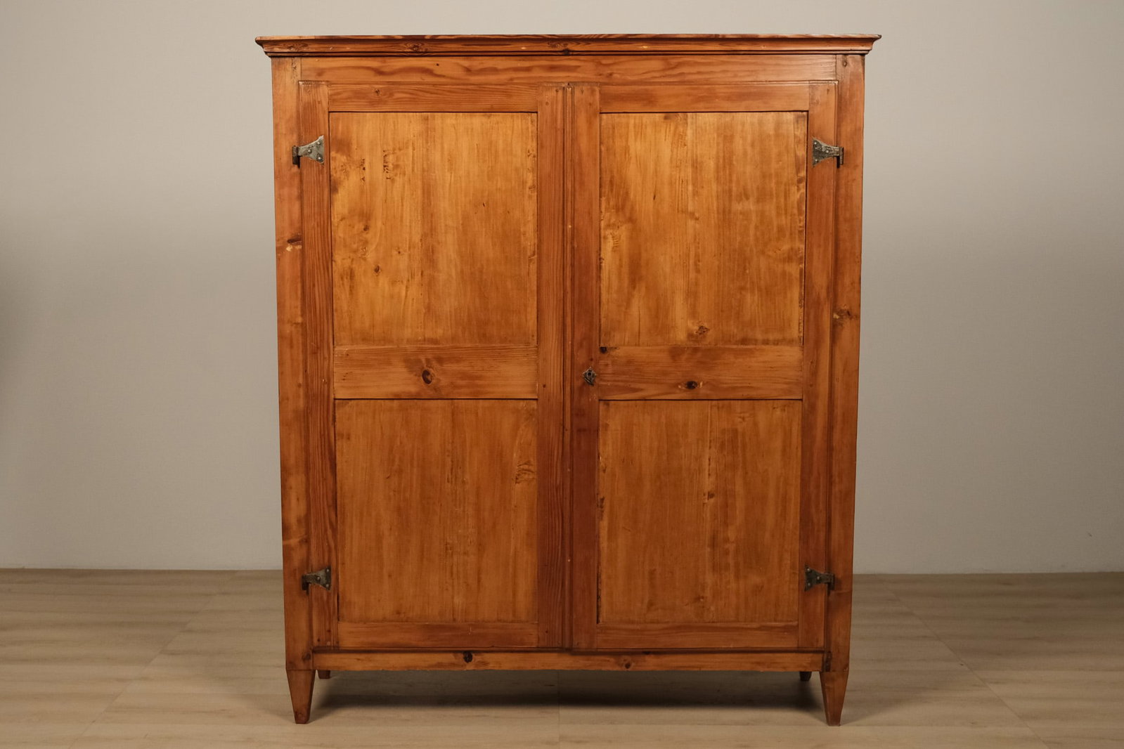 Italian Rustic Tuscan Pine Cupboard Cabinet: A rustic Tuscan-style pine cabinet with beautifully expressive grain. The tall, architectural case is fitted with a molded cornice, two full-length paneled doors, and simple tapered feet. The