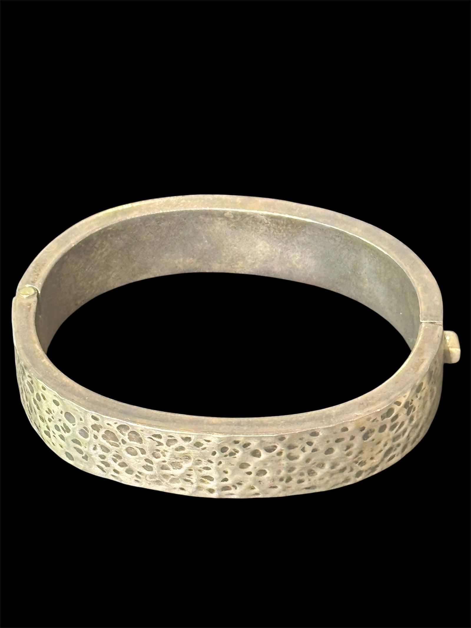 Vintage Sterling Silver Hinged Hammered Finish Bangle Bracelet: This is a vintage sterling silver hinged bangle bracelet featuring a textured hammered or dimple finish. The bracelet has a classic hinged design for ease of wear and displays an artisan-style