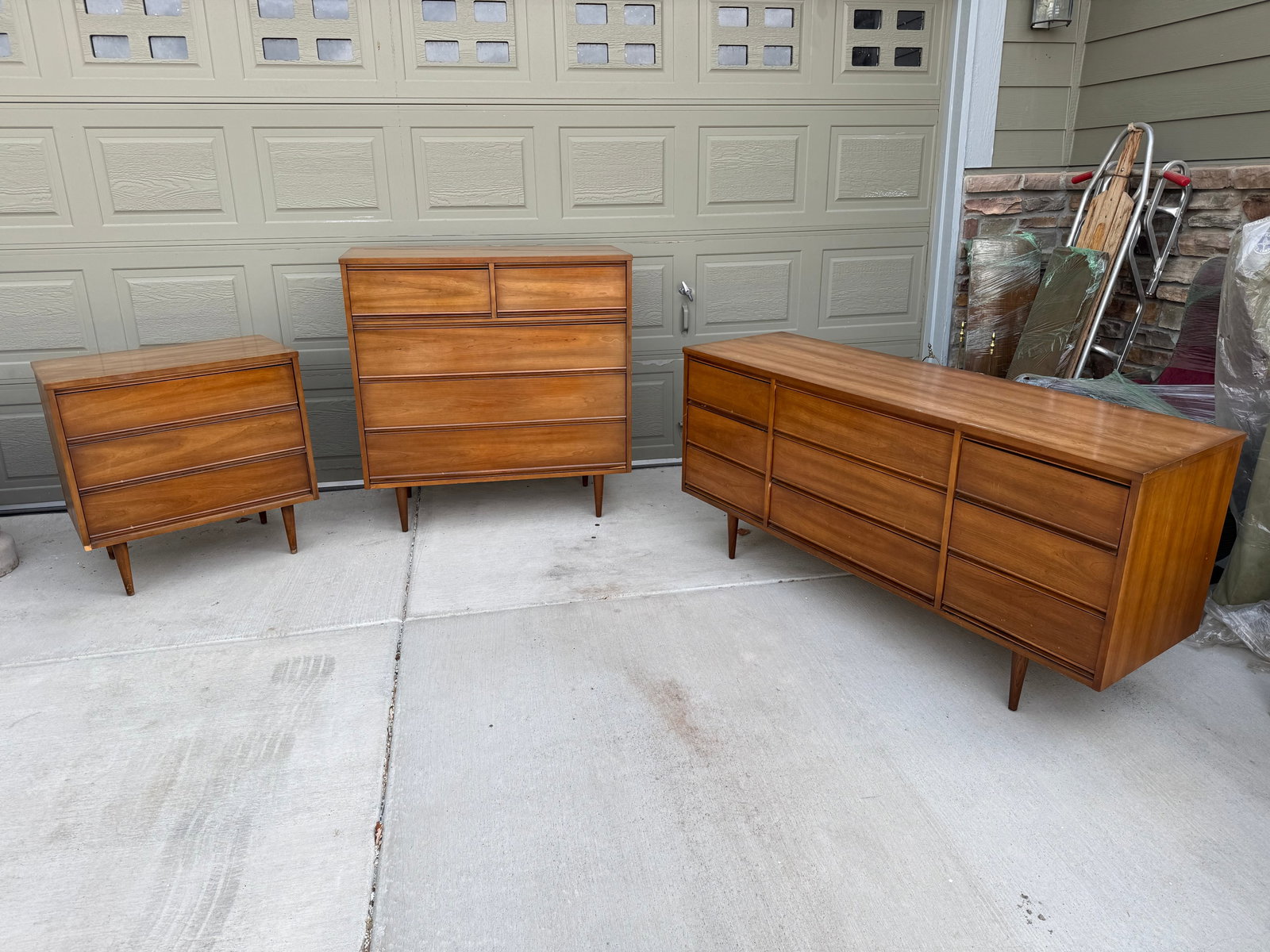 Mid Century Bedroom Set By Dixie: Three piece set by Dixie includes 3 drawer bachelor's chest, 5 drawer high boy, and 9 drawer dresser. Some minor scuffing as shown.Dimensions: 3 drawer- 30in H x 30in W x 19in D. 5 Drawer- 42in H x