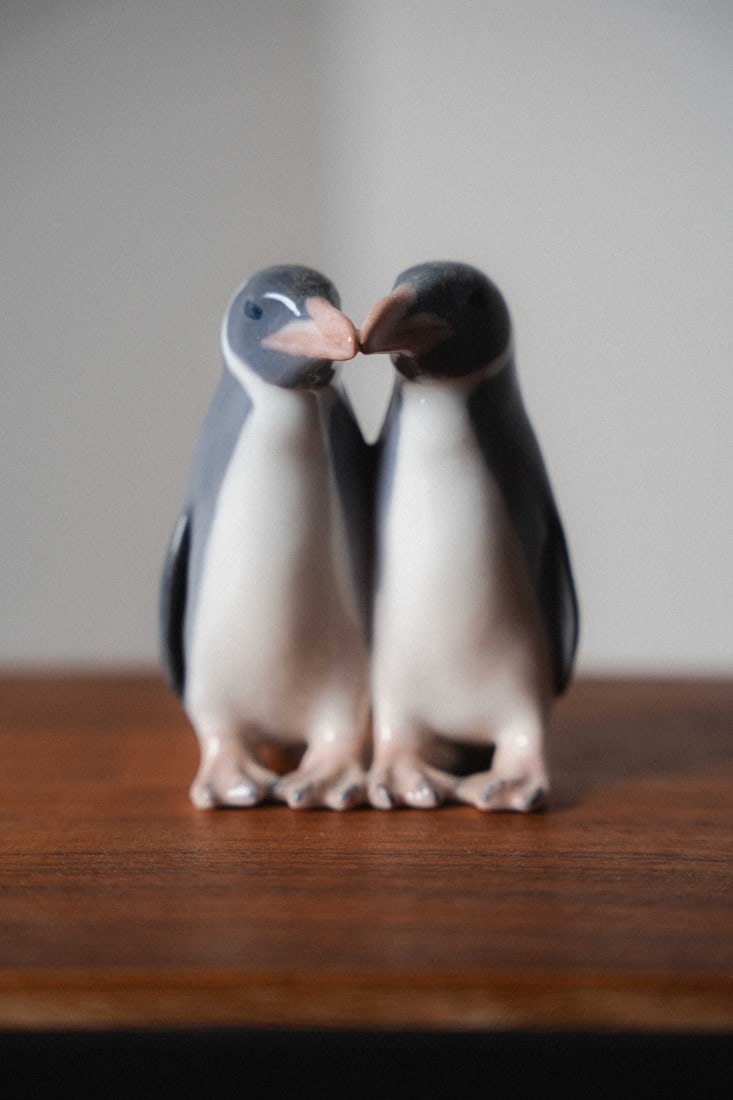 Penguins, Anna Trap, Royal Copenhagen Bing & Grondahl Porcelain Figurine #1190: Presenting a porcelain figurine by Bing & Grøndahl, crafted in Denmark. B&G, founded in 1853, is renowned for its high-quality porcelain, delicate modeling, and hand-painted finishes, producing figur