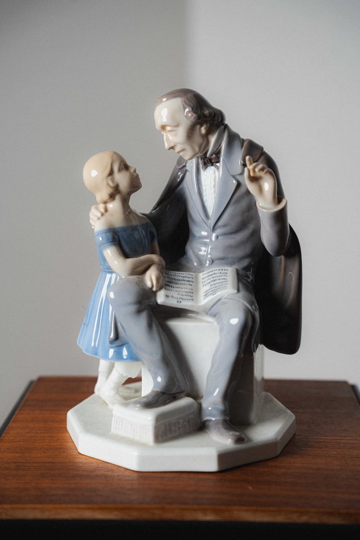 Henning Seidelin, Royal Copenhagen Bing & Grondahl Porcelain Figurine #2037, H. C. Andersen telling: Presenting a porcelain figurine by Bing & Grøndahl, crafted in Denmark. B&G, founded in 1853, is renowned for its high-quality porcelain, delicate modeling, and hand-painted finishes, producing