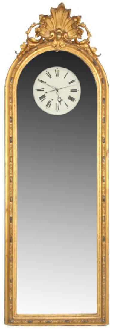 Unusual Lg. Gilt Carved 30 Day Mirror Clock: Unusual Lg. Gilt Carved 30 Day Mirror Clock. Large wall hanging case with gilt carved frame, seashell and pierced filigree crest and mirror with 14 in. aperture exposing the dial. 12.5 in. dial painte