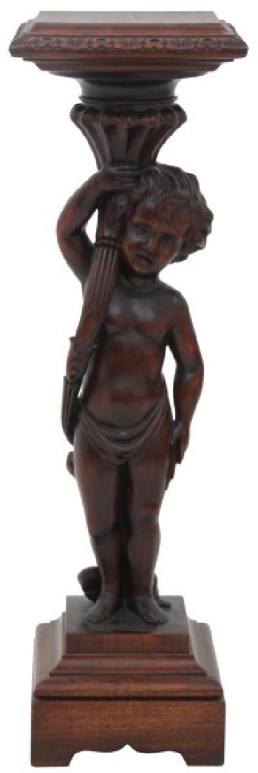 Mahogany Figural Carved Putti Pedestal: Mahogany Figural Carved Putti Pedestal. Standing putti figure holding cornucopia under a square top with filigree carved edge. A 20th century version in excellent condition 38.25 in. high x 11.5 in. w