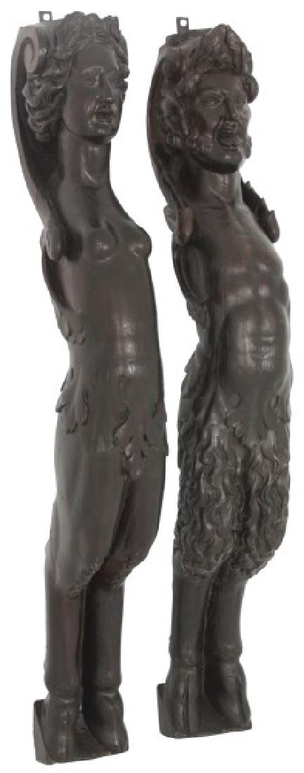 Pr. Carved Oak Figural Winged Corbels: Pr. Carved Oak Figural Winged Corbels. Large nude winged figures of a man and woman with leaf carving at the waist, and has hoofed feet; dark brown refinish, both are in good overall condition. 50.5 i