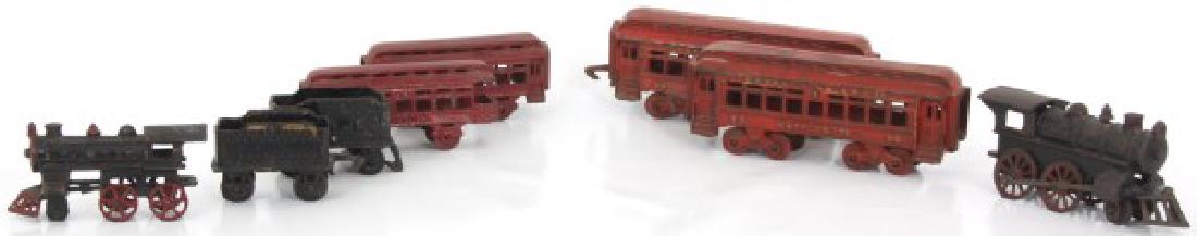2 Cast Iron Toy Train Sets: 2 Cast Iron Toy Train Sets. 4 pieces each with engine, coal car, passenger car and caboose, the large set measures 3.75 in. high x 30 in. long and the smaller set measures 3 in. high x 23.5 in. long.
