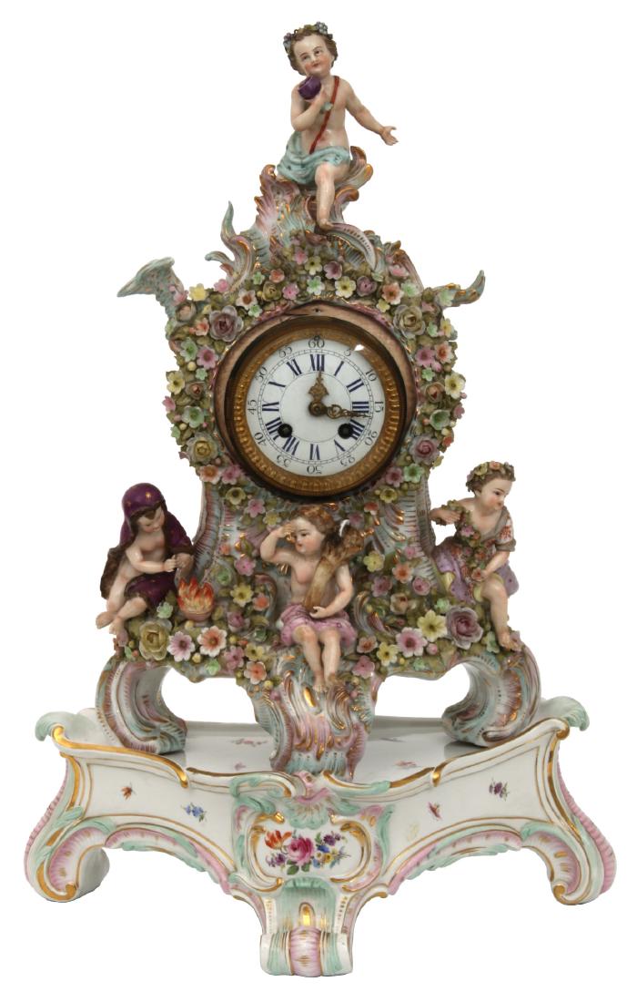 Meissen 4 Seasons Mantle Clock On Base: Meissen 4 Seasons Mantle Clock On Base. 3.5 in. porcelain dial with blue Roman hour numerals, 5 minute numbers, gilt pierced hands, brass hinged door bezel with beveled convex crystal and painted depi
