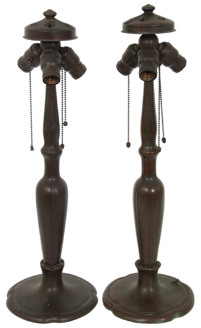 2 Signed Handel Stick Lamp Bases: 2 Signed Handel Stick Lamp Bases. Stick form, spelter, spherical 3 socket light cluster with heat cap and finial. 1 has original sockets and acorn pulls, the other has 1 replaced socket innard and 2 r