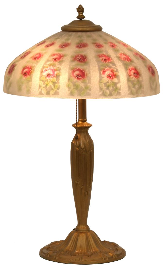 14 in. Pittsburgh Rose Table Lamp: 14 in. dia. obverse painted shade with red roses on white striped panels on a textured surface; has reverse painted green leafy highlights, excellent condition. On a cast iron Pittsburgh base with rel