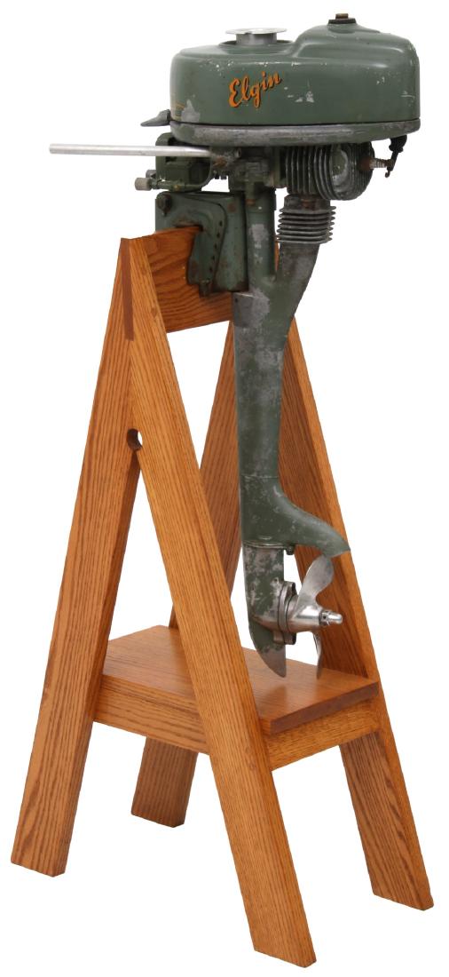 Elgin Outboard Motor: Elgin Outboard Motor. c.1946, 1.25hp air cooled motor, model number 57158301. The Elgin outboard was retailed by Sears & Roebuck. 34 in. high x 7.5 in. wide x 18 in. deep. On a custom oak display stan