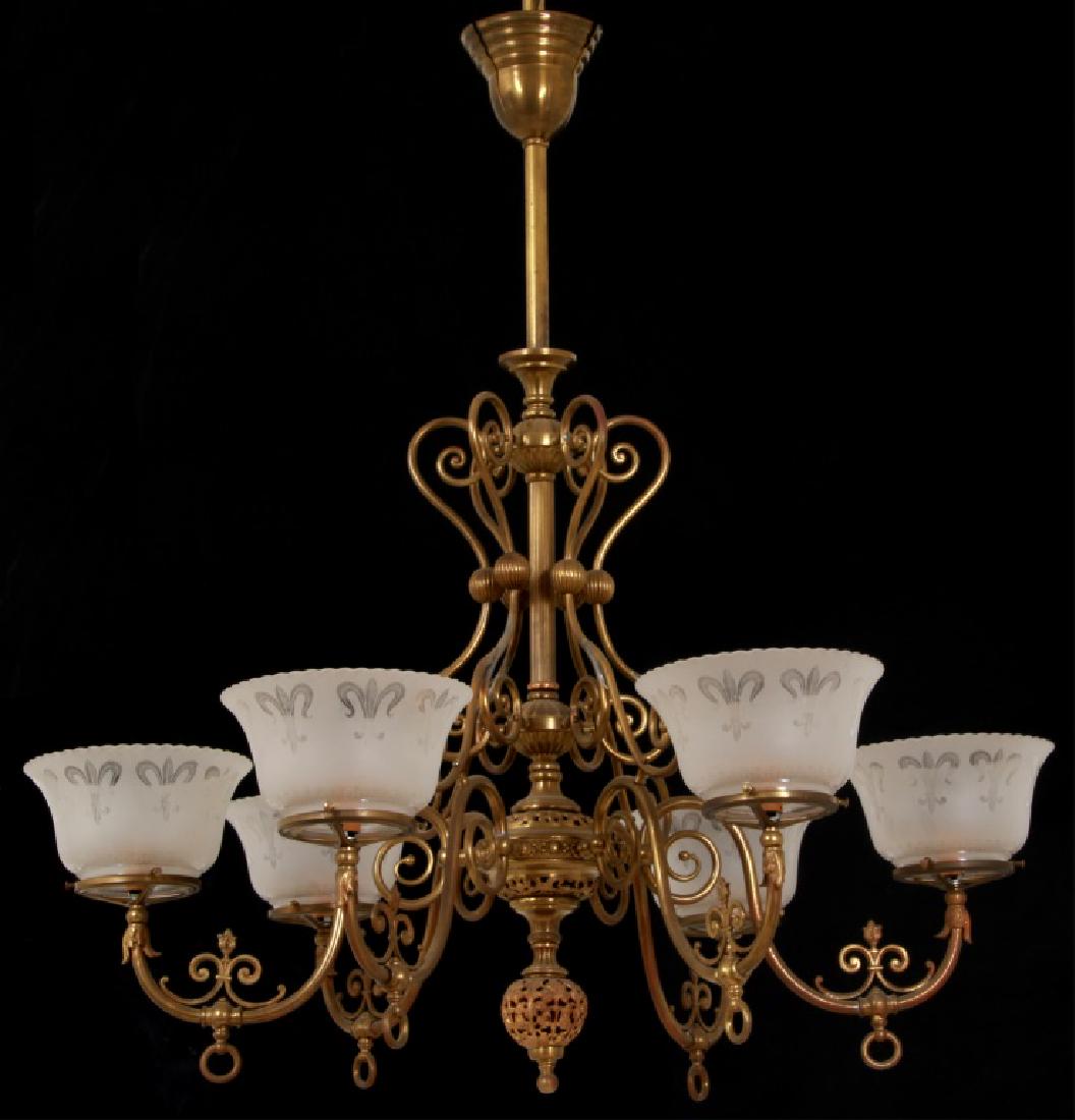 Brass 6 Arm Gasolier: Brass 6 Arm Gasolier. Long center stem with pierced decorated clusters and 6 fancy scrolling arms with valve switches at the bottom and electrified with single candle light sockets pointing up. With p